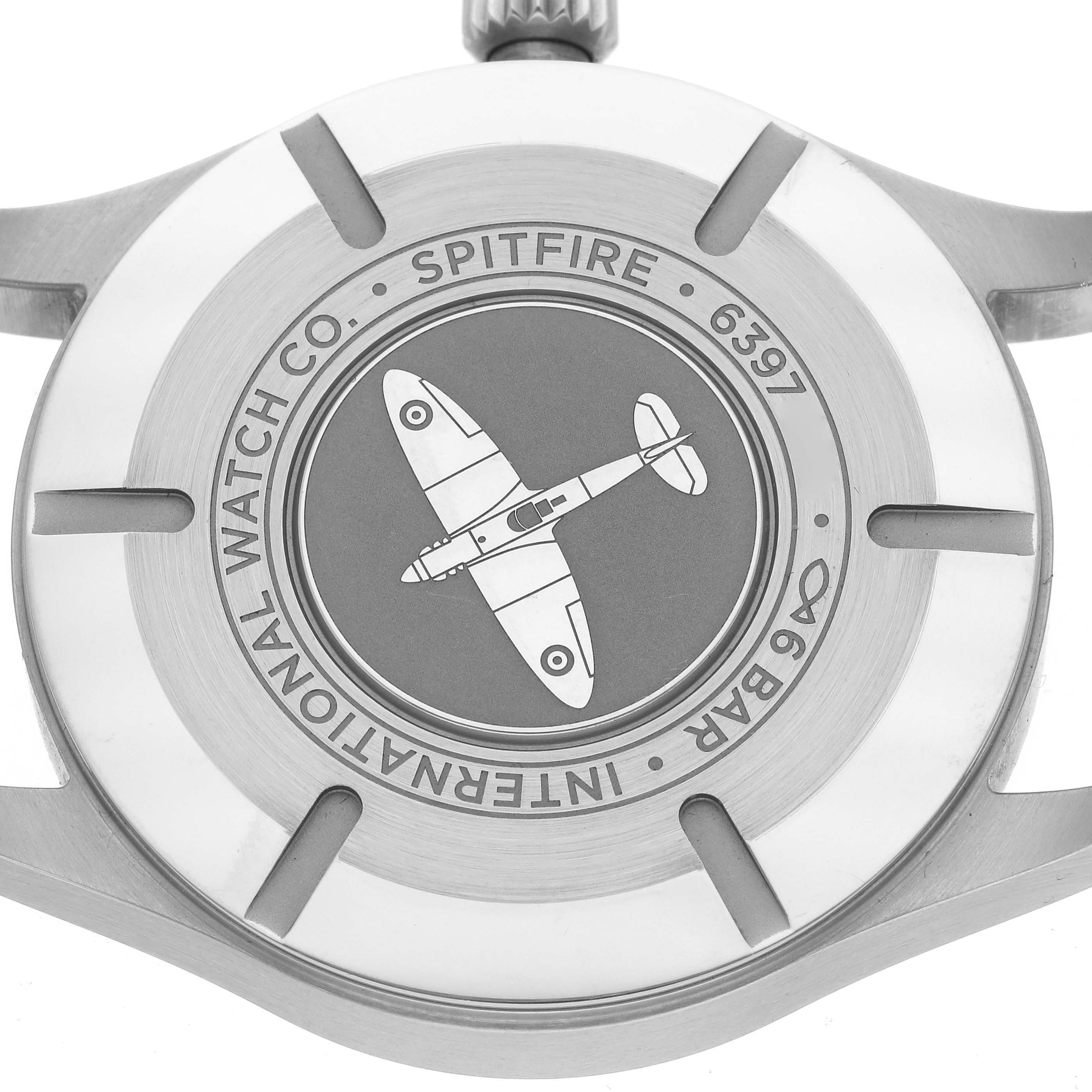 The image shows the case back of the IWC Pilot IW326801 Men's Stainless Steel Black Dial IW326801 Men's Stainless Steel Black Dial Spitfire watch, featuring an engraved airplane design.