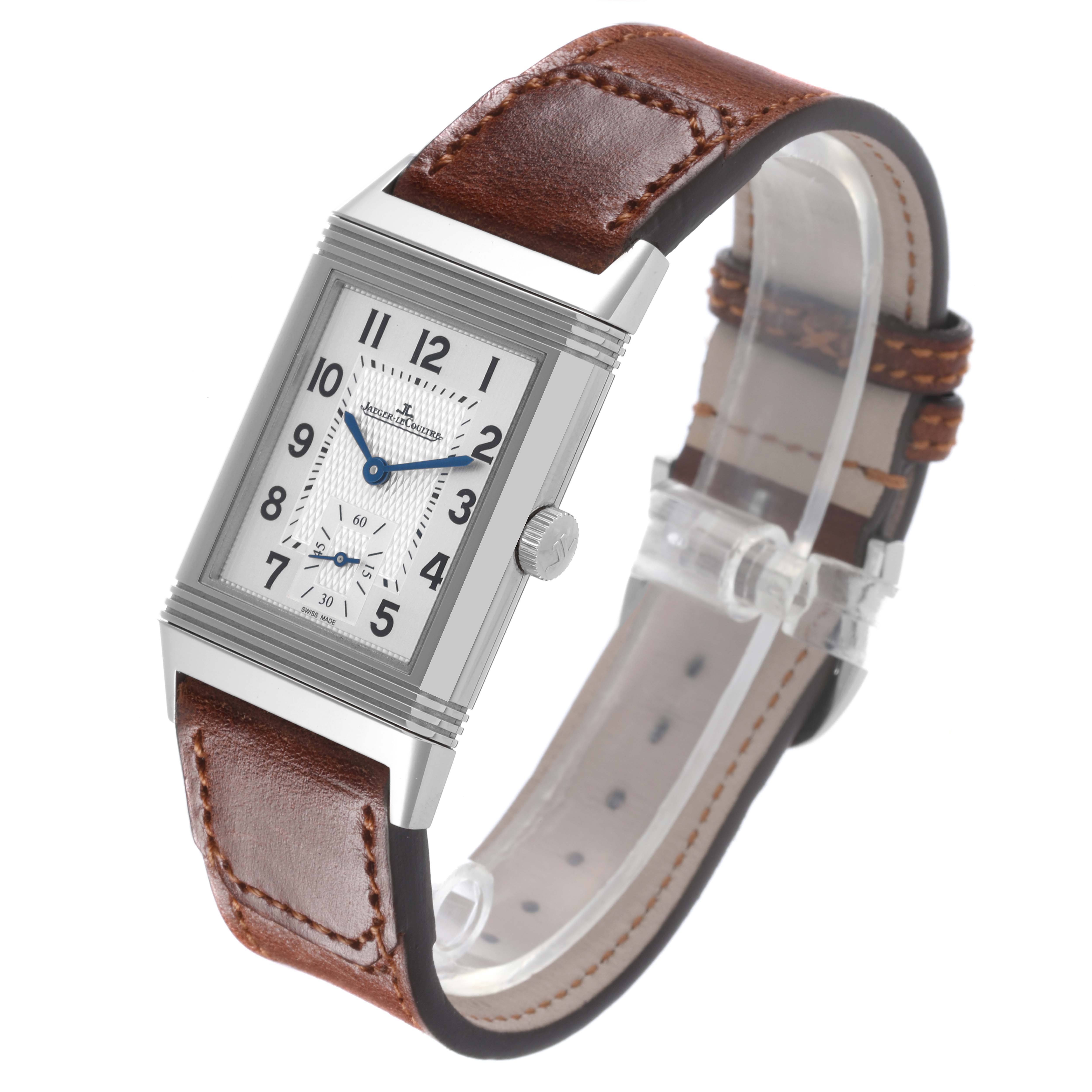 The Jaeger-LeCoultre Reverso watch is shown at a 3/4 angle, featuring its rectangular face and brown leather strap.