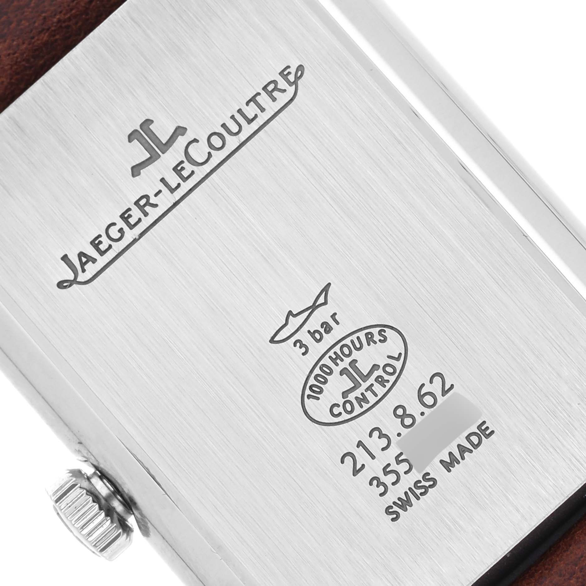 The image shows the back of a Jaeger-LeCoultre Reverso watch, displaying the brand, model details, and crown.