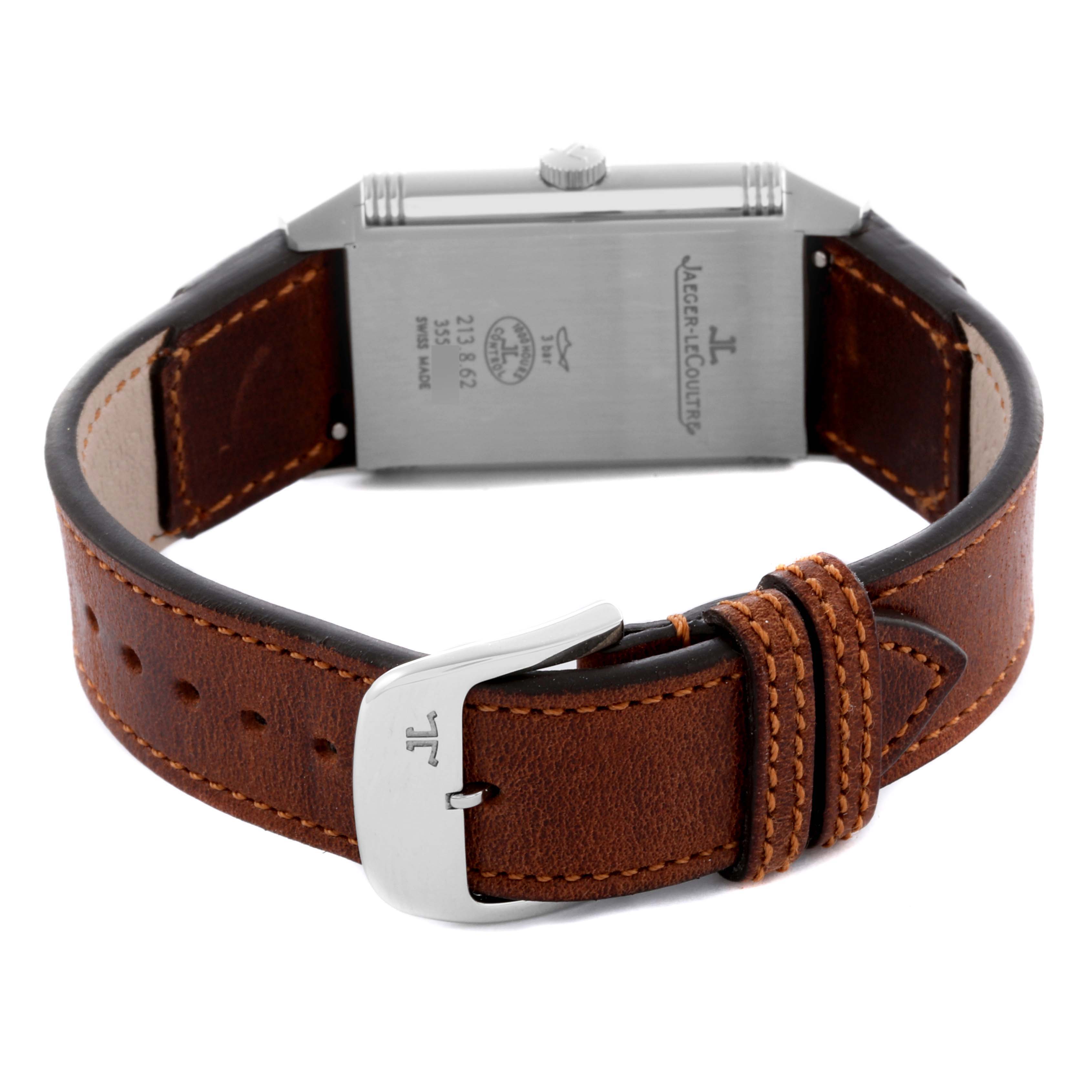 The image shows the back of the Jaeger-LeCoultre Reverso watch, highlighting the case back, crown, and brown leather strap with a buckle.