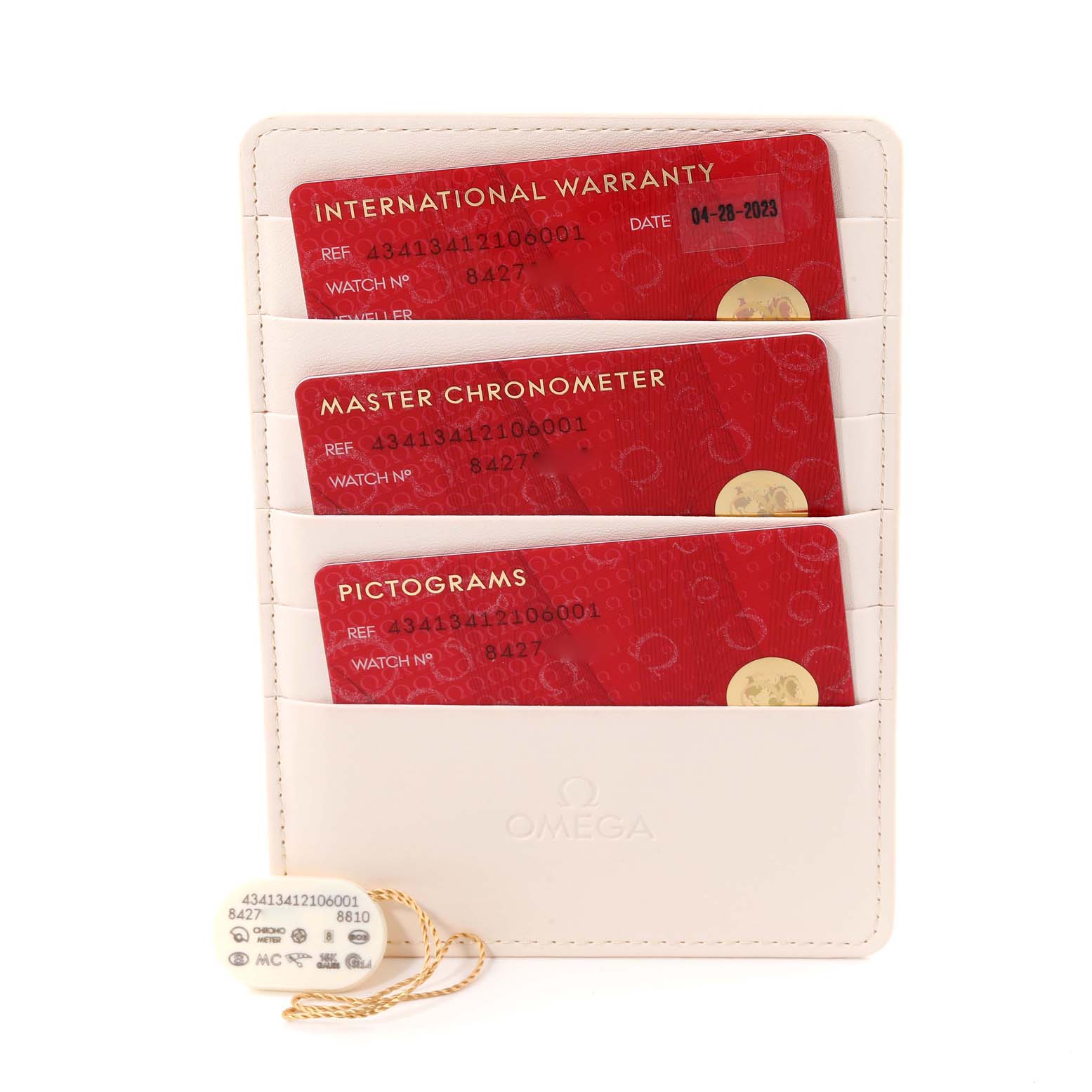 The image shows International Warranty, Master Chronometer, and Pictograms cards for the Omega De Ville 434.13.41.21.06.001 Men's Stainless Steel Grey Dial 434.13.41.21.06.001 Men's Stainless Steel Grey Dial watch, along with a tag.