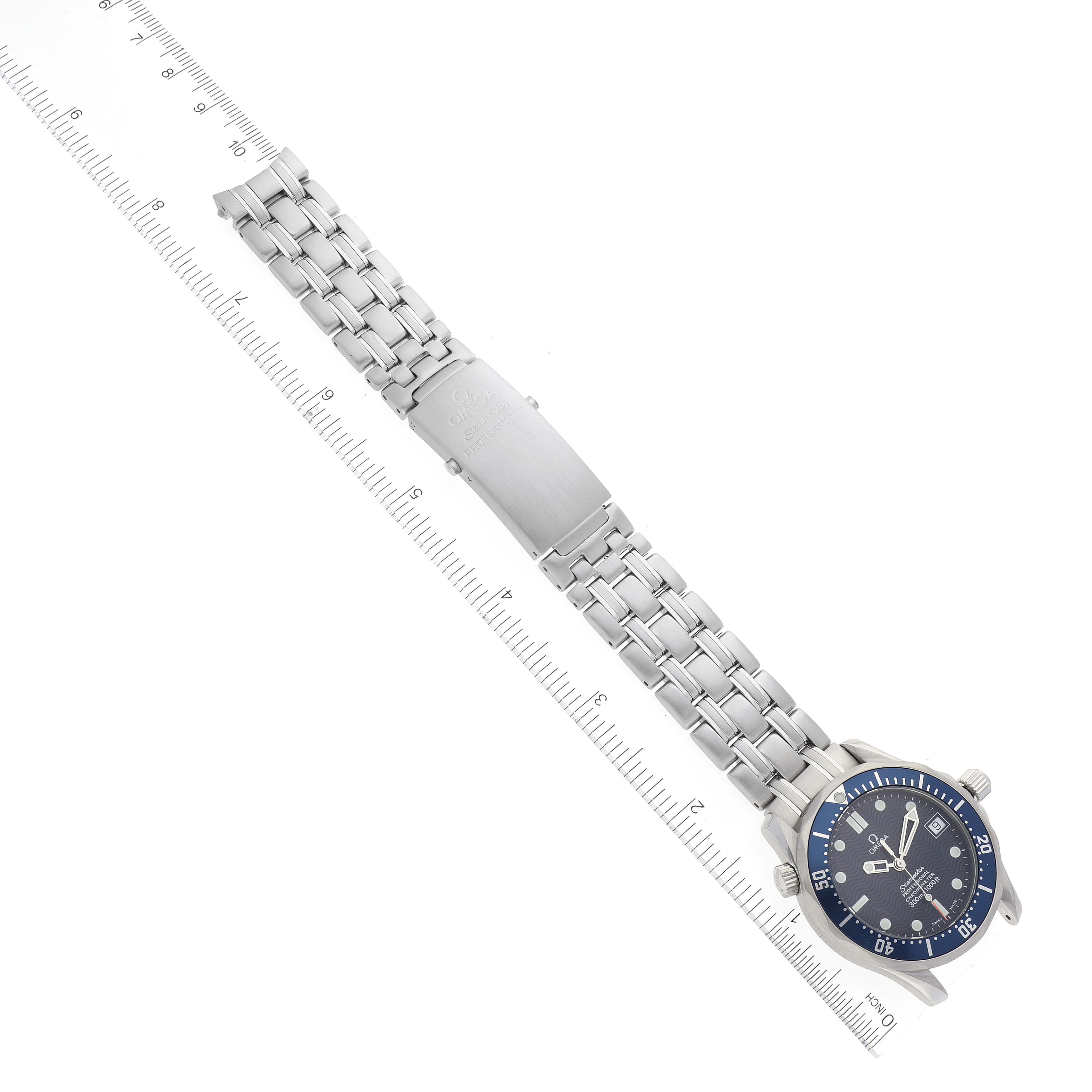 The Omega Seamaster 2551.80.00 Men's Stainless Steel Blue Dial 2551.80.00 Men's Stainless Steel Blue Dial watch is displayed horizontally, showing its blue dial, bezel, and stainless steel bracelet with a clasp, alongside a ruler.