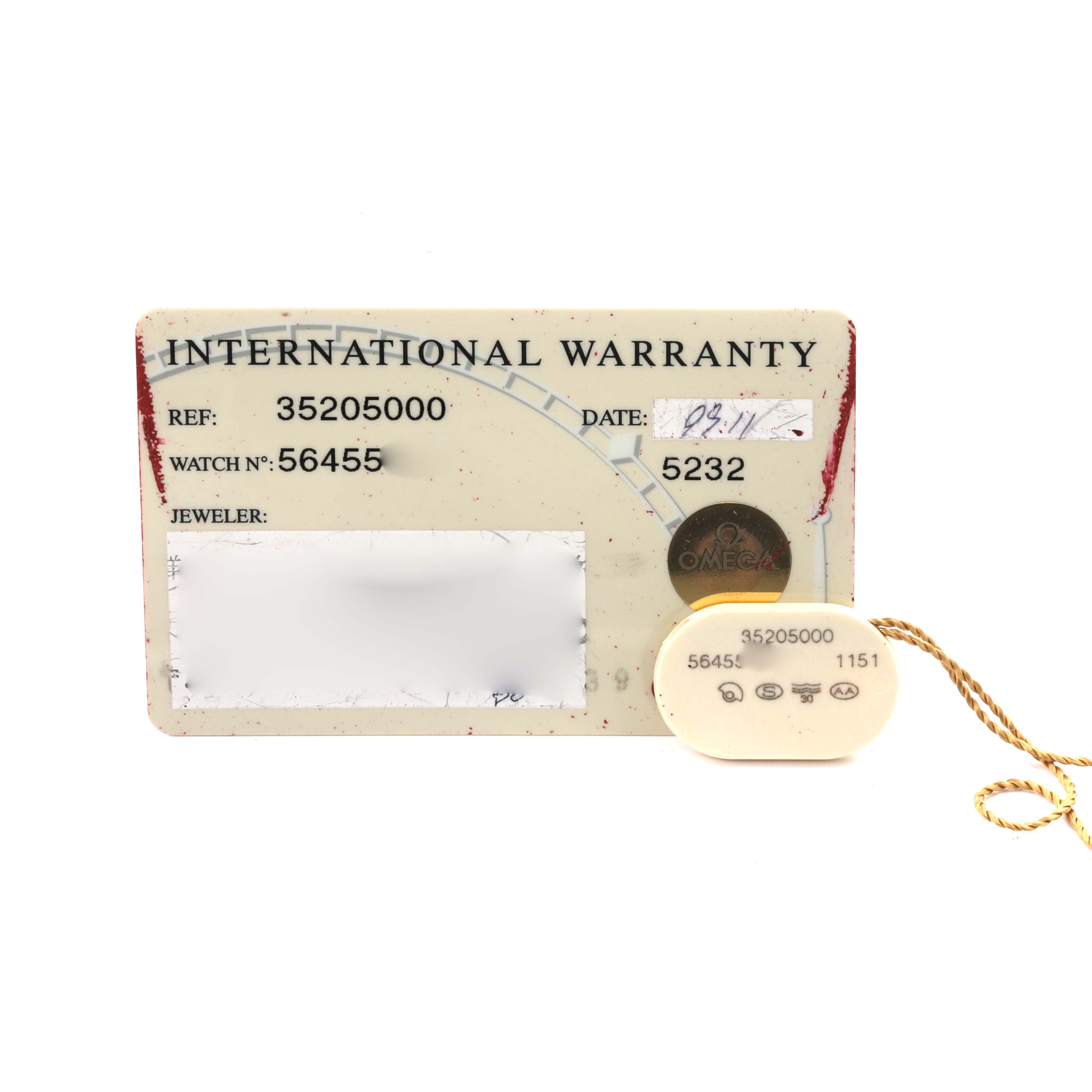 The image shows an Omega Speedmaster 3520.50.00 Men
s Stainless Steel Black Dial 3520.50.00 Men
s Stainless Steel Black Dial International Warranty card and tag with reference numbers.