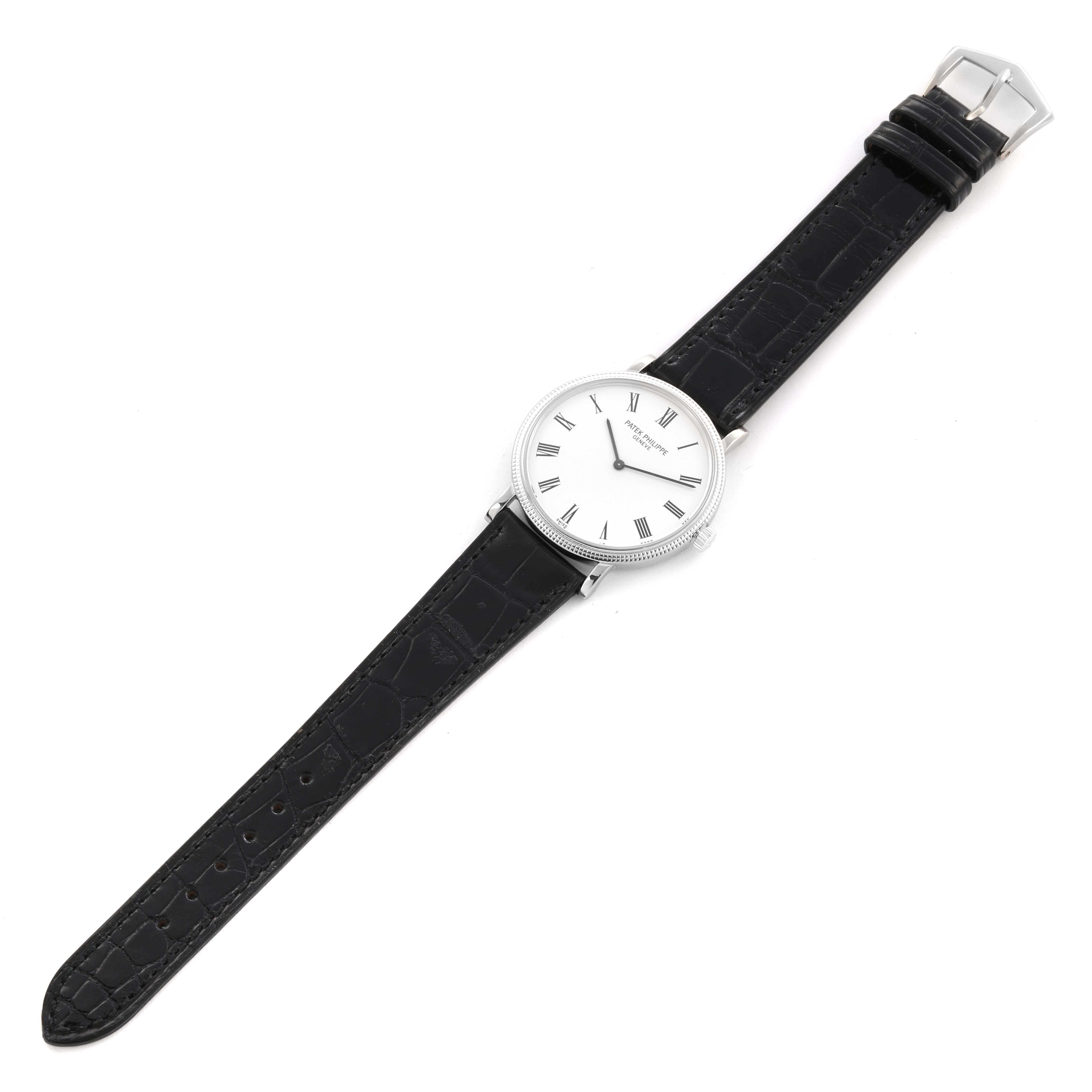 The Patek Philippe Calatrava 5120G-001 Men's White Gold White Dial 5120G-001 Men's White Gold White Dial watch is shown from a top-down angle, displaying its face, bezel, and black leather strap.