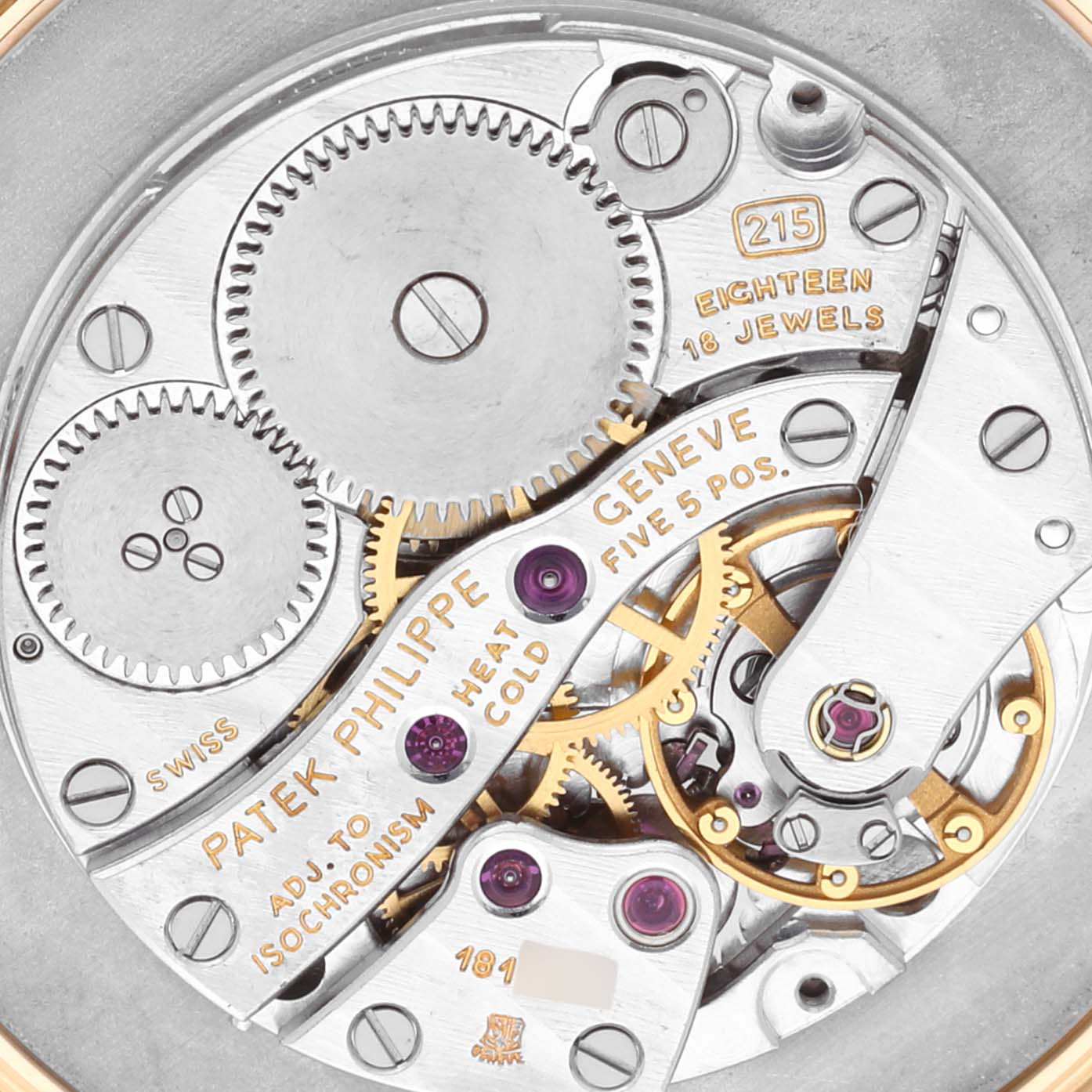 The image shows a close-up of the Patek Philippe Calatrava 3919J Men's Yellow Gold White Dial 3919J Men's Yellow Gold White Dial watch movement, highlighting its gears and jewel elements.