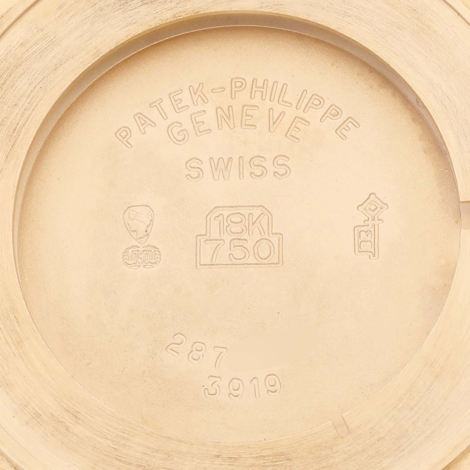 The image shows the case back of a Patek Philippe Calatrava 3919J Men's Yellow Gold White Dial 3919J Men's Yellow Gold White Dial watch, highlighting gold hallmarks and engravings.