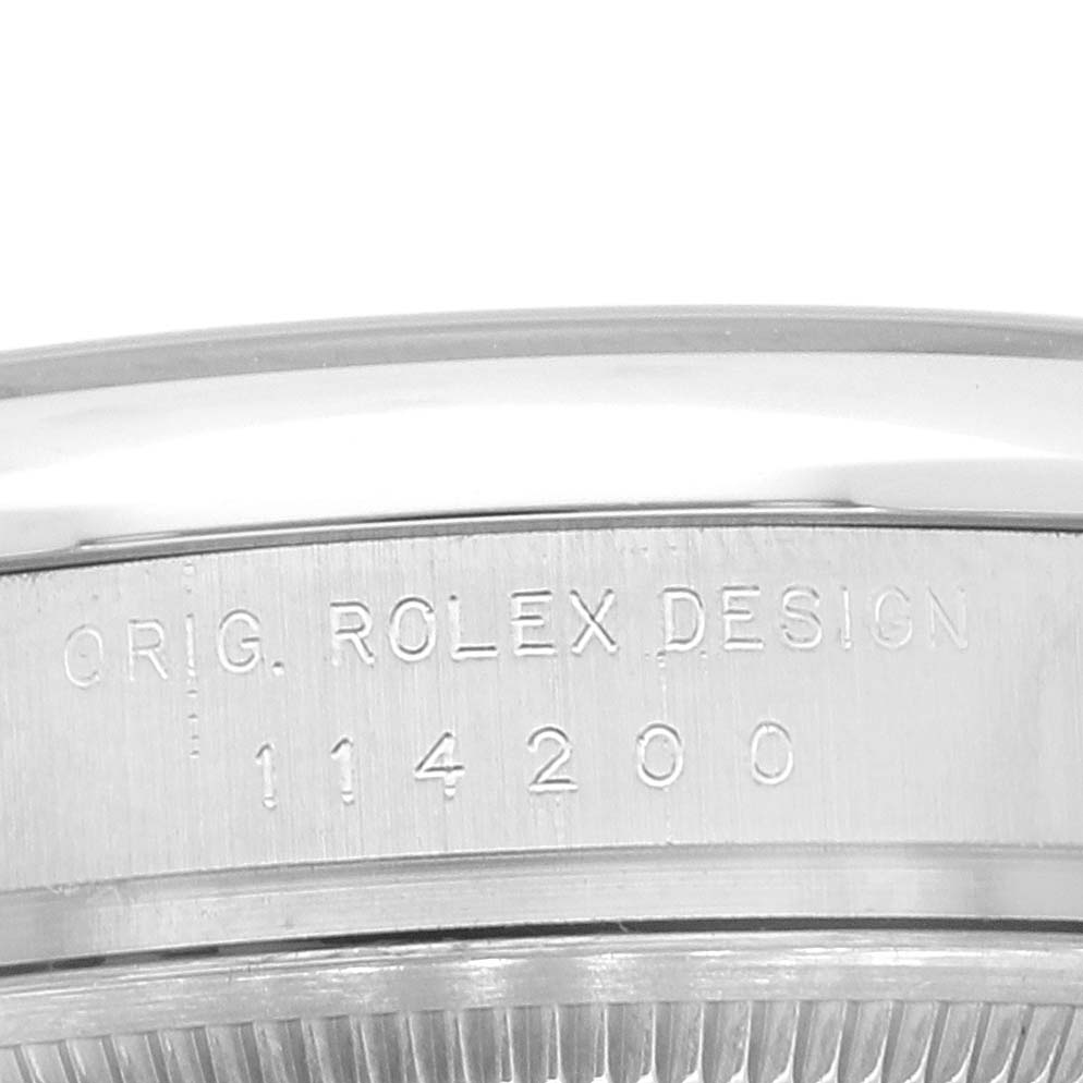 This close-up shows the side view of the bezel and case with engravings on a Rolex Air-King 114200 Men's Stainless Steel Silver Dial 114200 Men's Stainless Steel Silver Dial model.