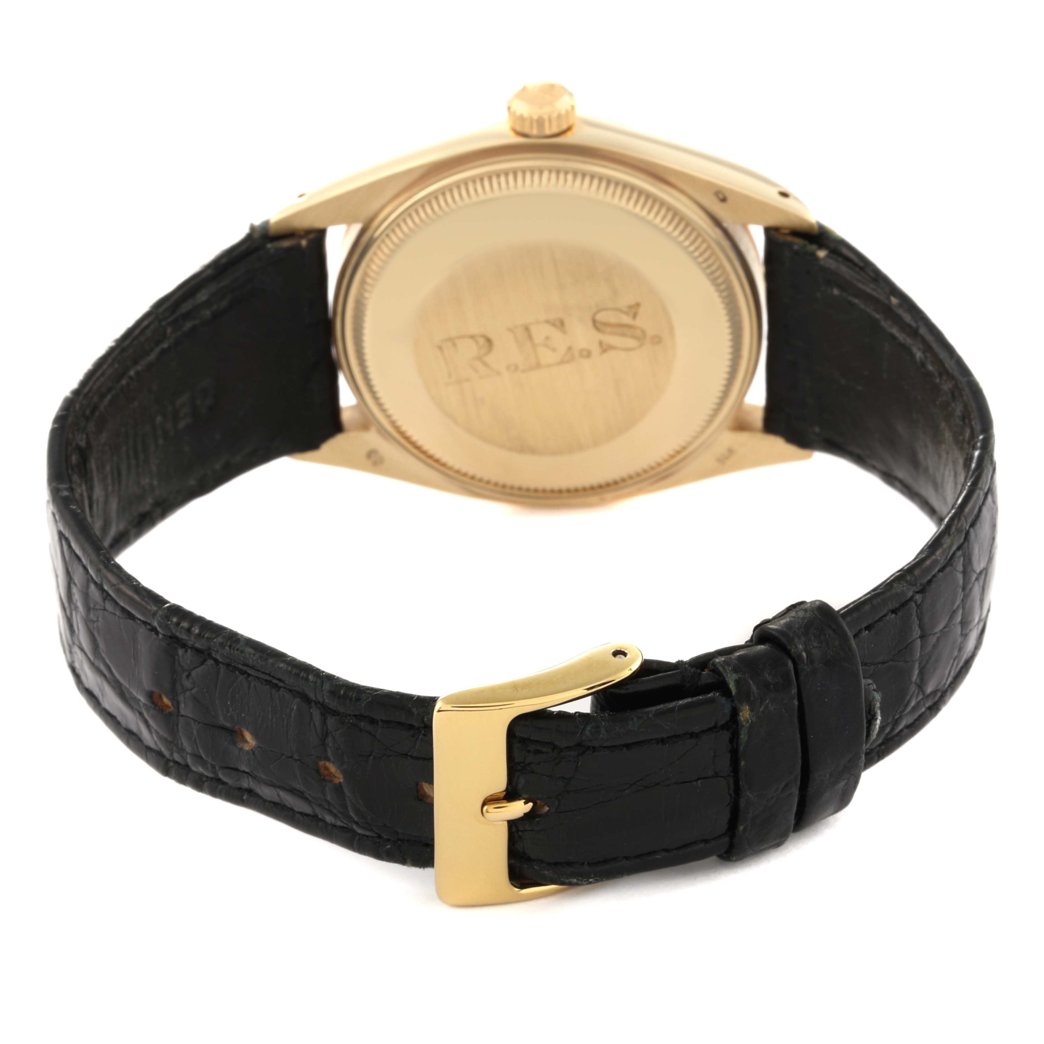 The image shows the back case, crown, and black leather strap with a gold buckle of a Vintage Collection model by Rolex.