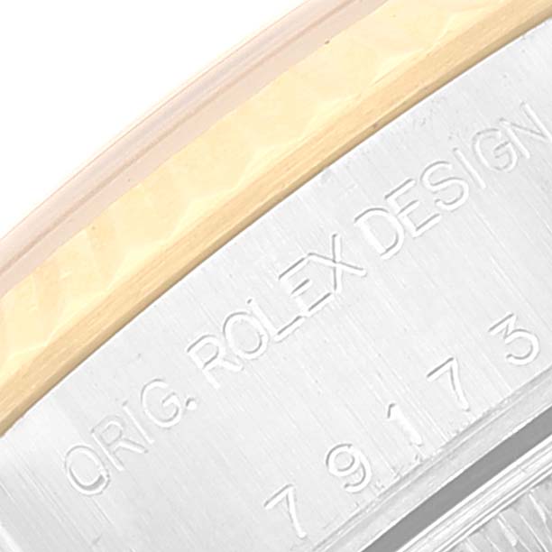 This close-up image shows the edge of the case and part of the engraving of a Rolex Datejust 79173 Women's Steel and Gold (two tone) White Dial 79173 Women's Steel and Gold (two tone) White Dial watch.