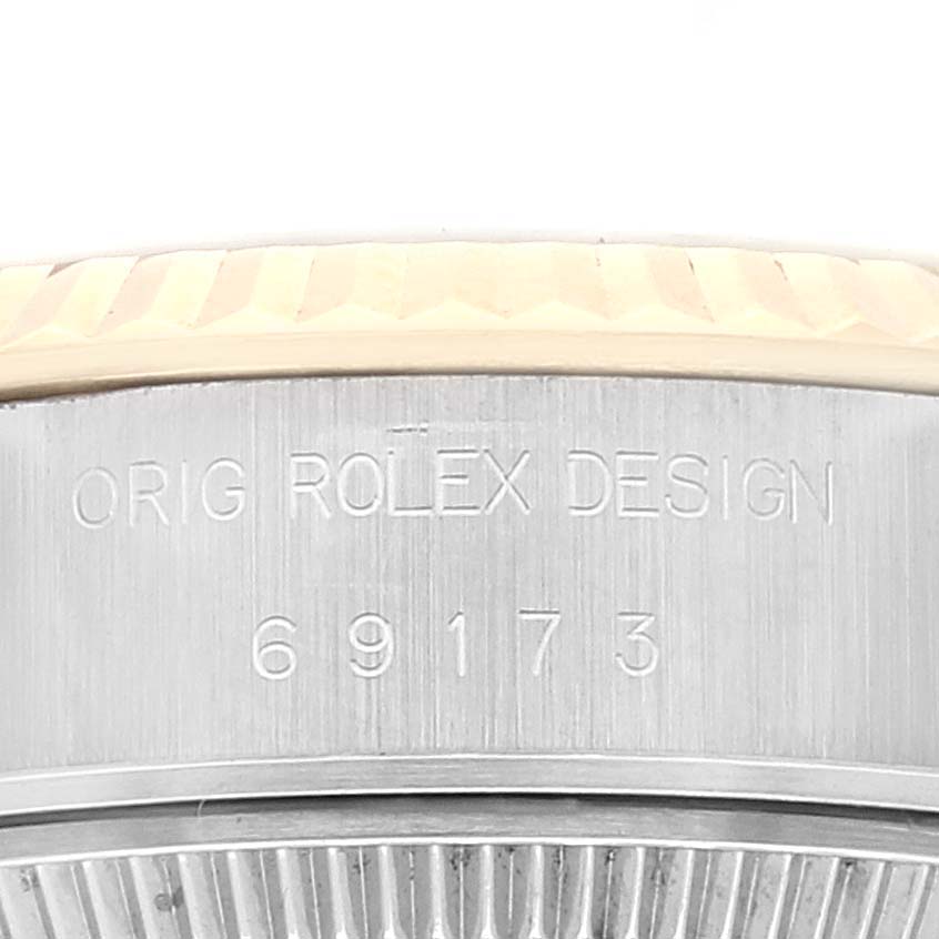 This image shows the side of a Rolex Datejust 69173 Women's Steel and Gold (two tone) Champagne Dial 69173 Women's Steel and Gold (two tone) Champagne Dial watch, focusing on the case engraving that includes "ORIG ROLEX DESIGN" and the model number "69173".