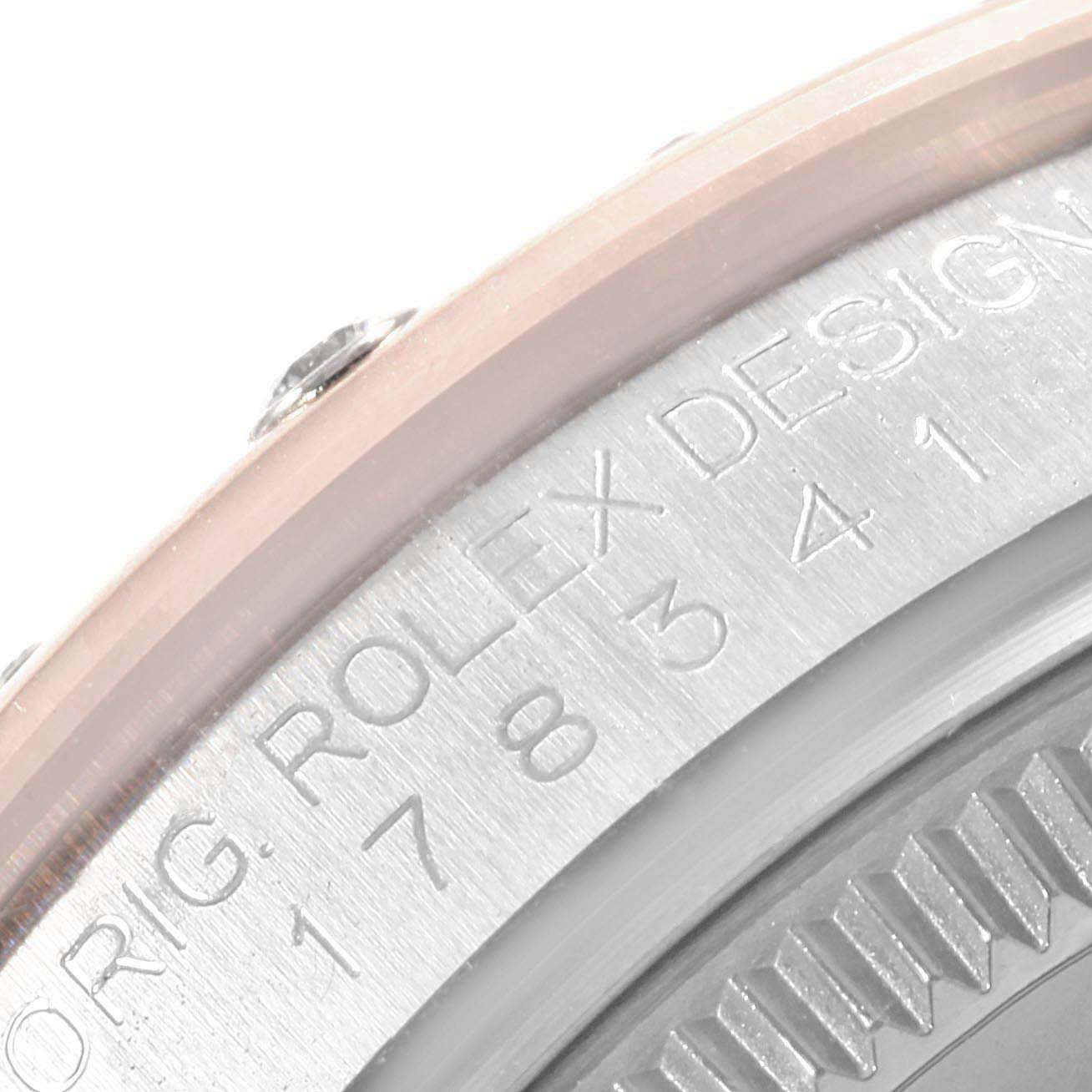 The close-up image shows a portion of the bezel and engraved side of the Mid-Size Rolex watch.