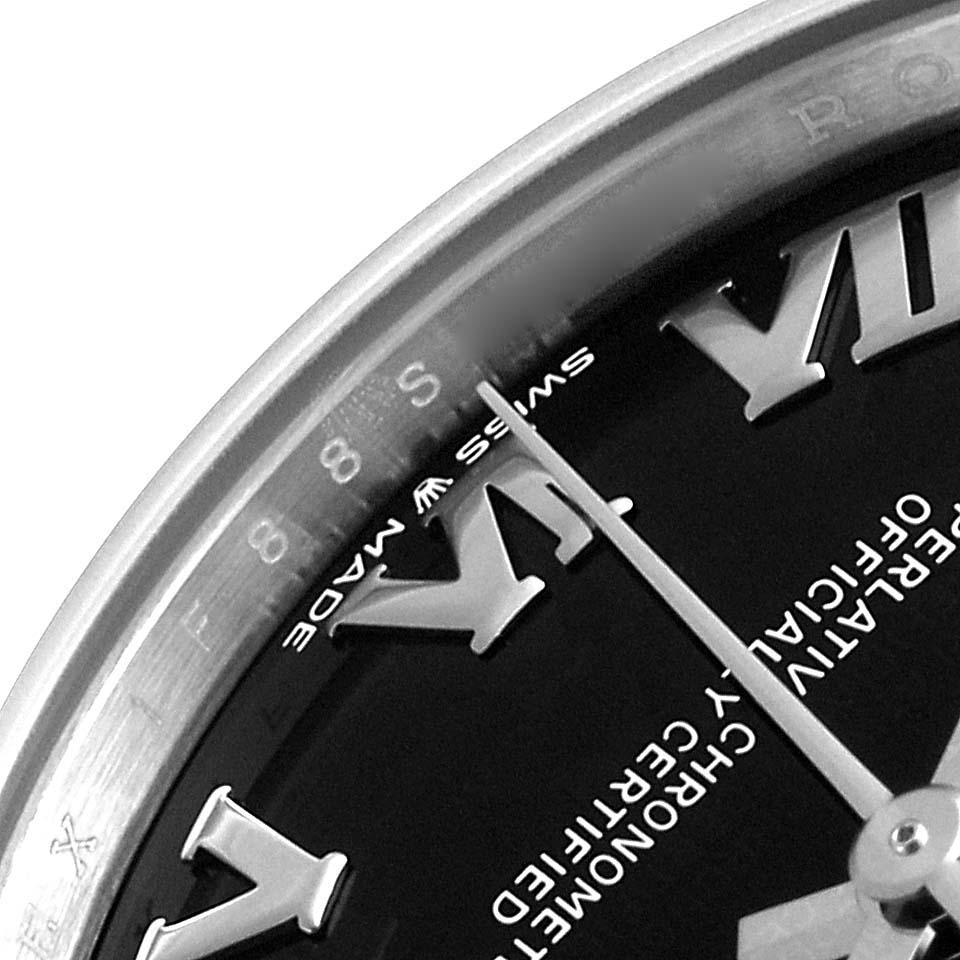 The image shows a close-up of the dial and part of the bezel of a mid-size Rolex watch, focusing on the numeral markers and text.