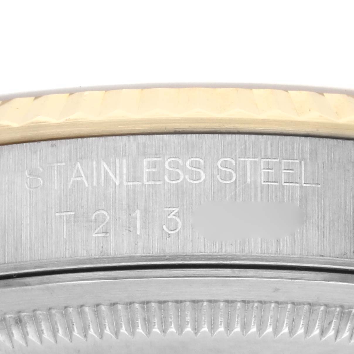 The image shows a close-up of the side of a Rolex Datejust 16233 Men's Steel and Gold (two tone) Champagne Dial 16233 Men's Steel and Gold (two tone) Champagne Dial, highlighting the stainless steel part with engraved text.