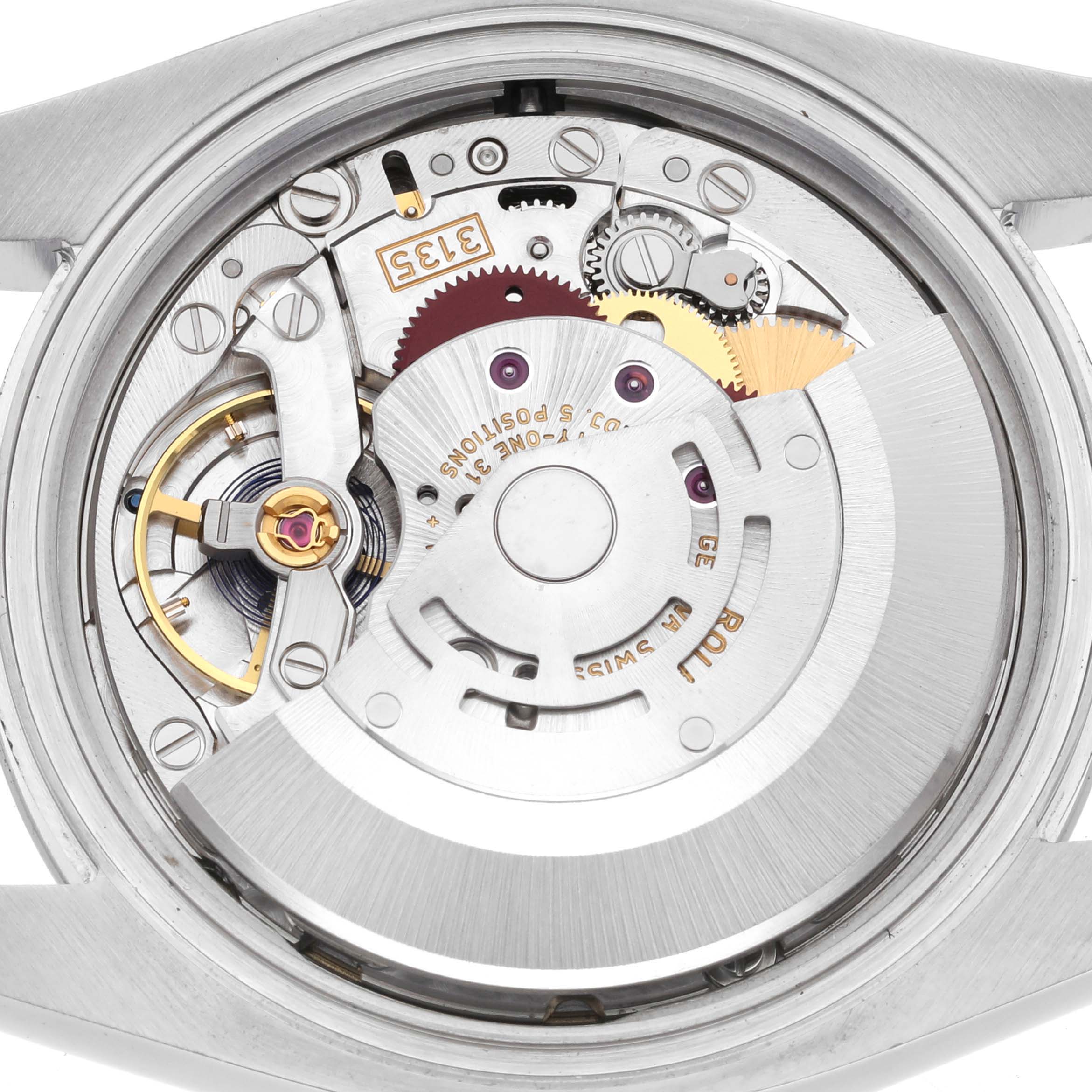 The image shows the intricate movement and mechanism of a Rolex Datejust 116200 Men
s Stainless Steel Blue Dial 116200 Men
s Stainless Steel Blue Dial watch from a rear angle.