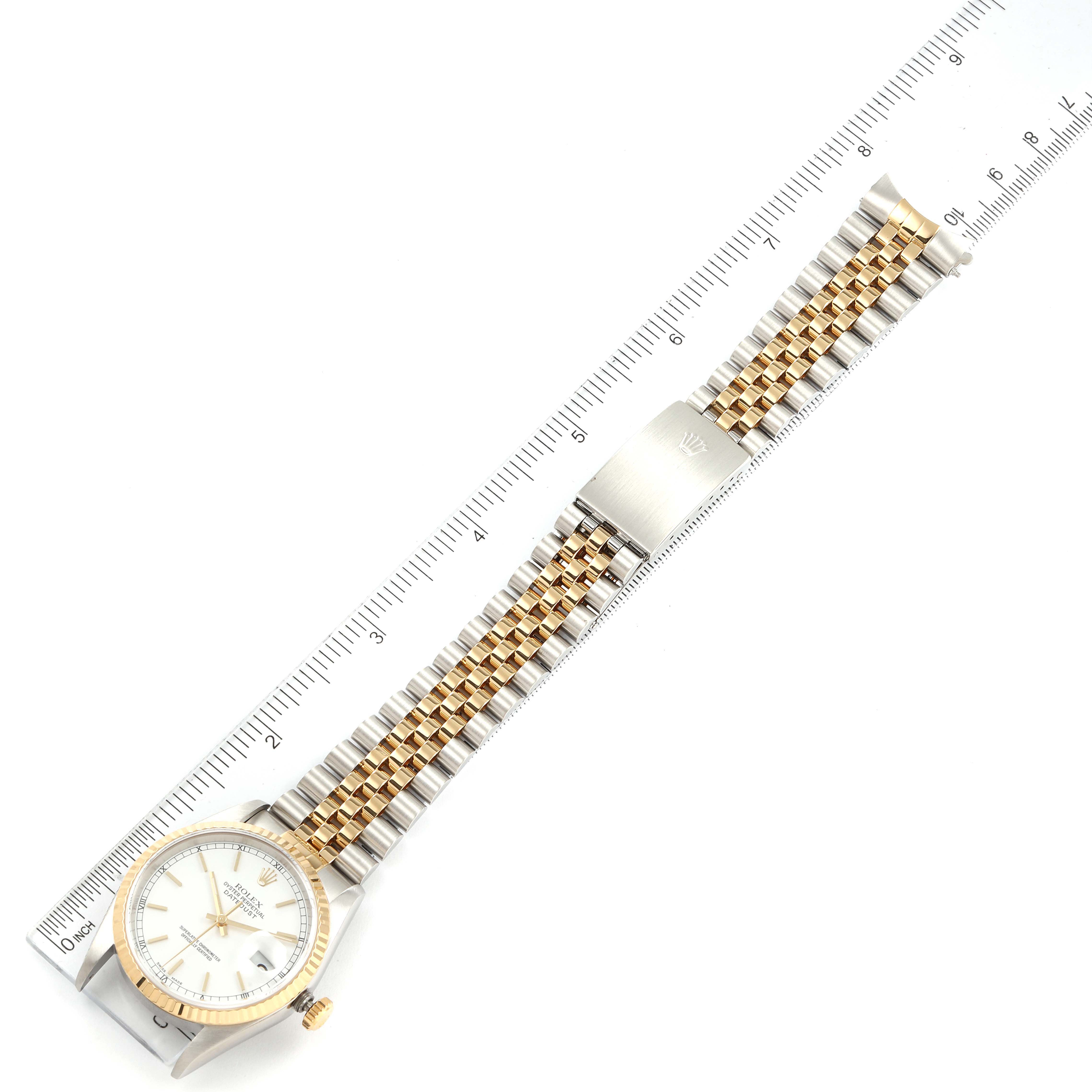 The image shows a Rolex Datejust 16233 Men's Steel and Gold (two tone) White Dial 16233 Men's Steel and Gold (two tone) White Dial watch laid flat, including the face, bezel, and bracelet, with a ruler for scale.