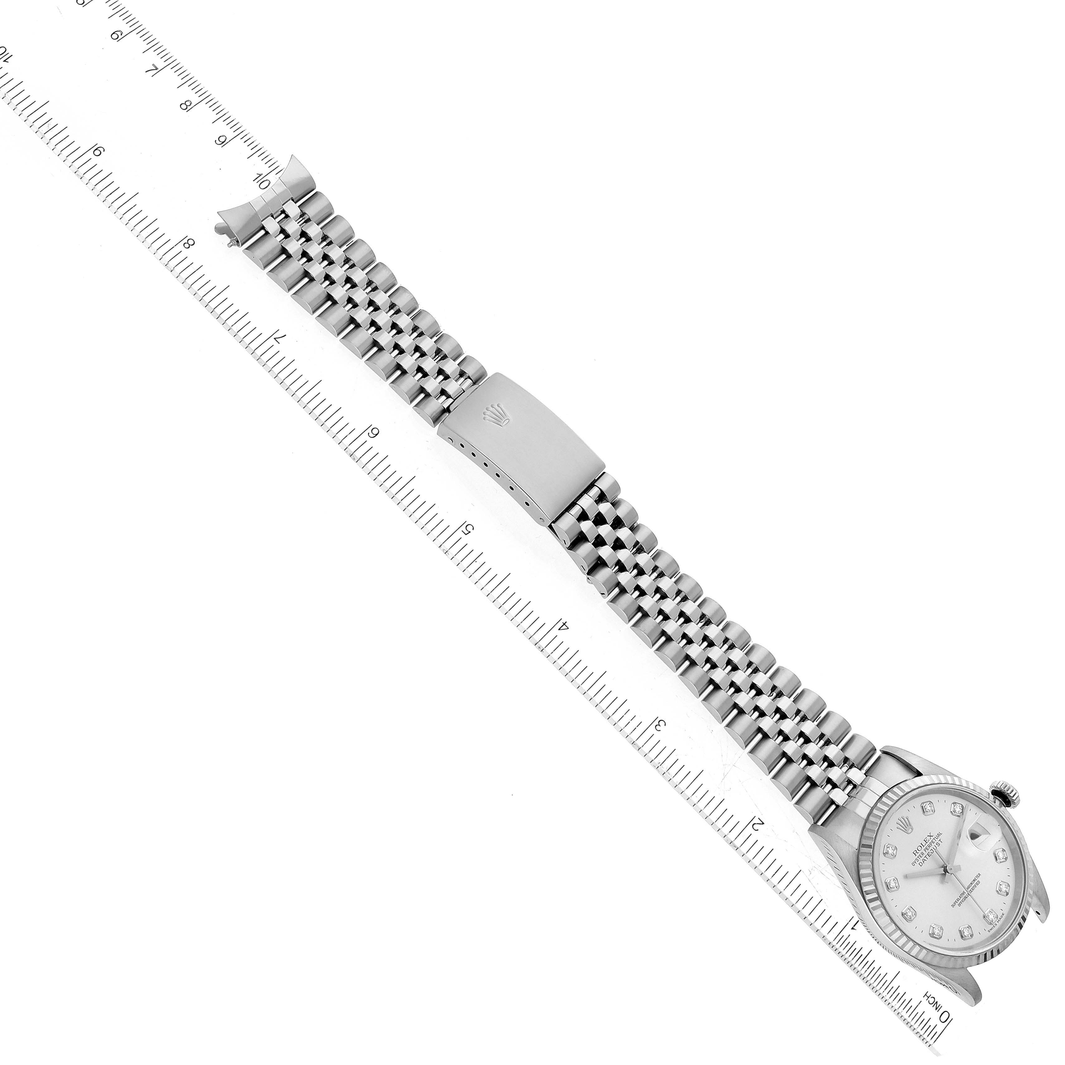 The Rolex Datejust 16234 Men's Stainless Steel Silver Dial 16234 Men's Stainless Steel Silver Dial watch is shown from a top-down angle, displaying the face, bracelet, and clasp alongside a ruler for scale.