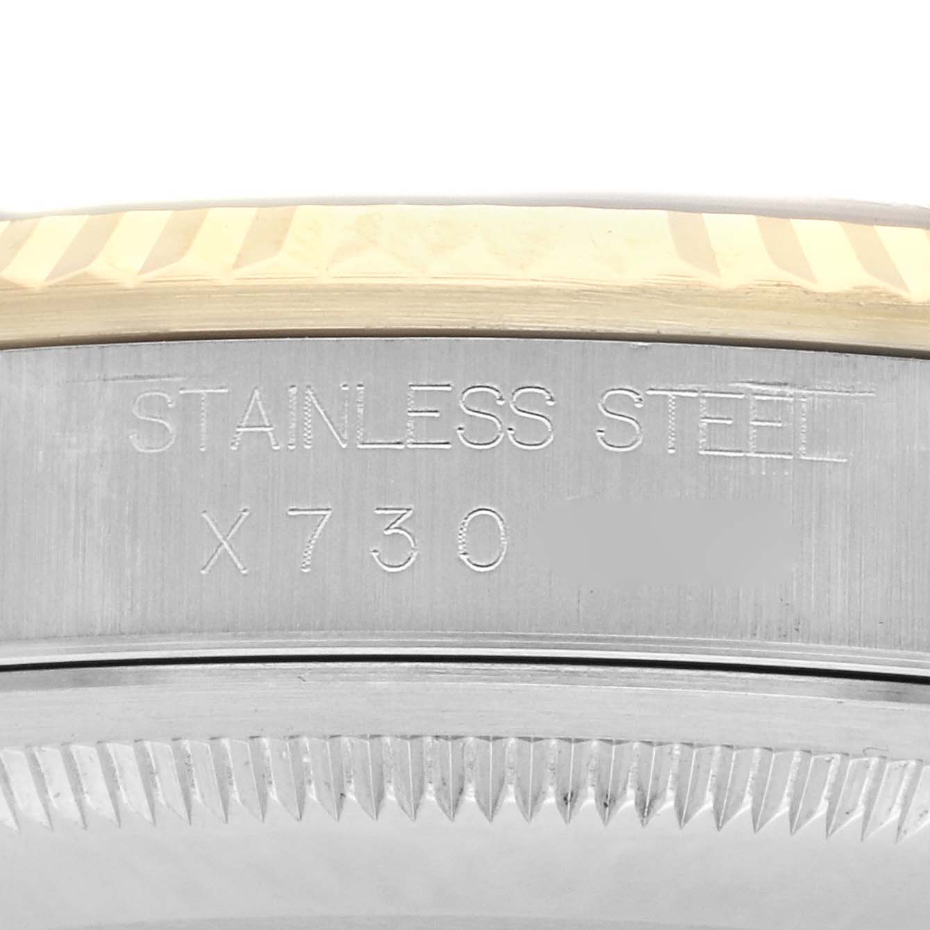 The image shows a close-up of the side of a Rolex Datejust 16233 Men's Steel and Gold (two tone) Champagne Dial 16233 Men's Steel and Gold (two tone) Champagne Dial, highlighting the engraved serial number and fluted bezel.