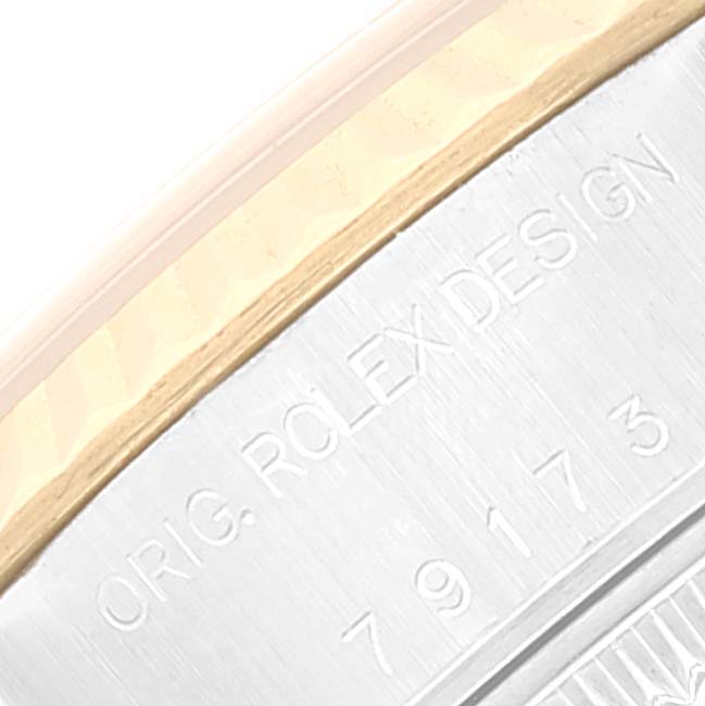 The image shows an angled close-up of the serial number and "ORIG. ROLEX DESIGN" inscription on a Rolex Datejust 79173 Women's Steel and Gold (two tone) Champagne Dial 79173 Women's Steel and Gold (two tone) Champagne Dial model.