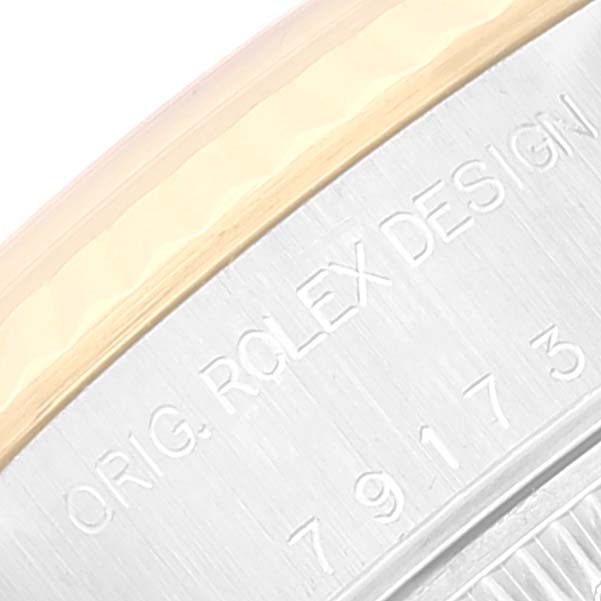 This is a close-up image of a Rolex Datejust 79173 Women's Steel and Gold (two tone) Mother of Pearl Dial 79173 Women's Steel and Gold (two tone) Mother of Pearl Dial watch, focusing on the part of the case with "ORIG. ROLEX DESIGN" engraved.