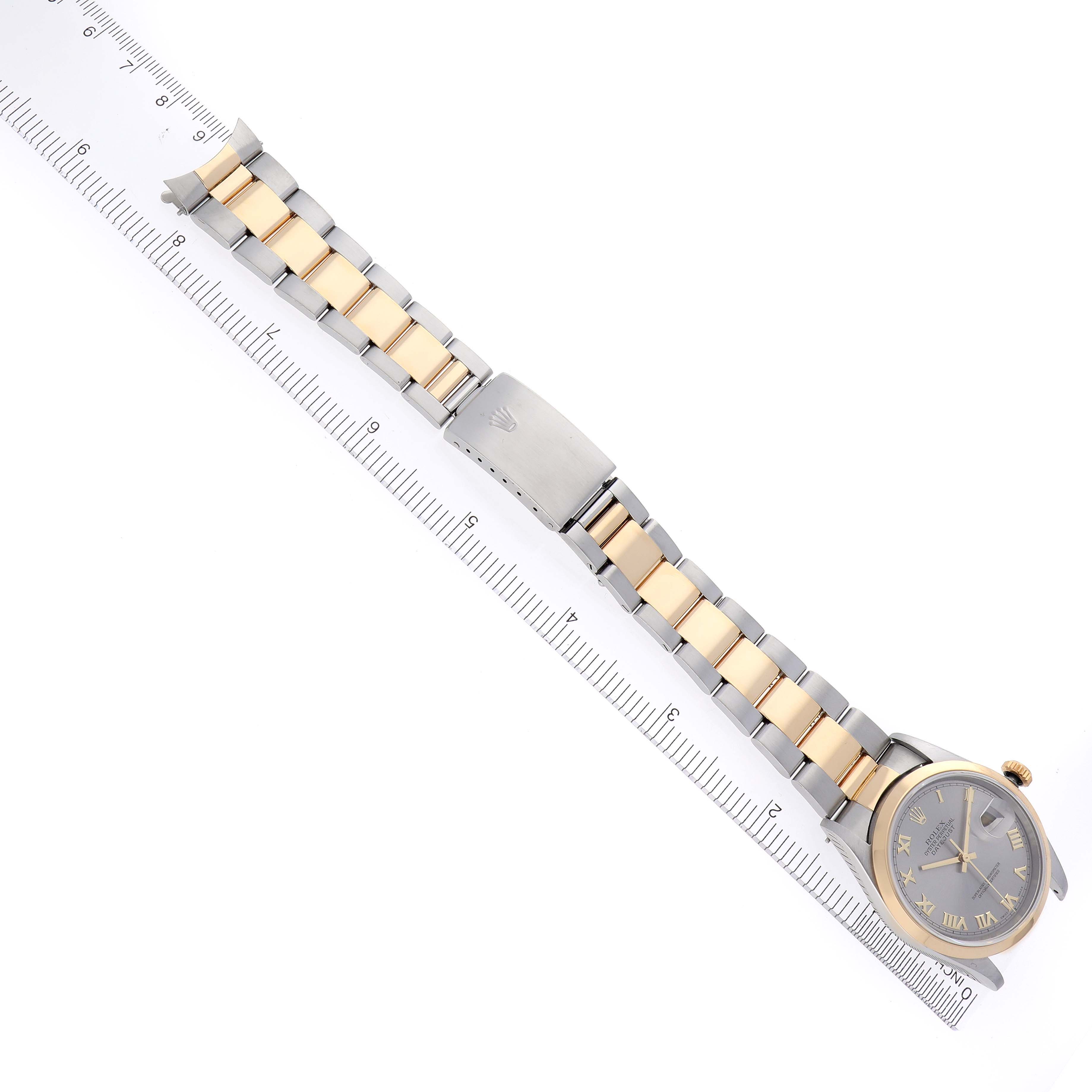 The Rolex Datejust 16203 Men's Steel and Gold (two tone) Grey Dial 16203 Men's Steel and Gold (two tone) Grey Dial watch is shown from the top angle, displaying the full bracelet, clasp, and face alongside a ruler.