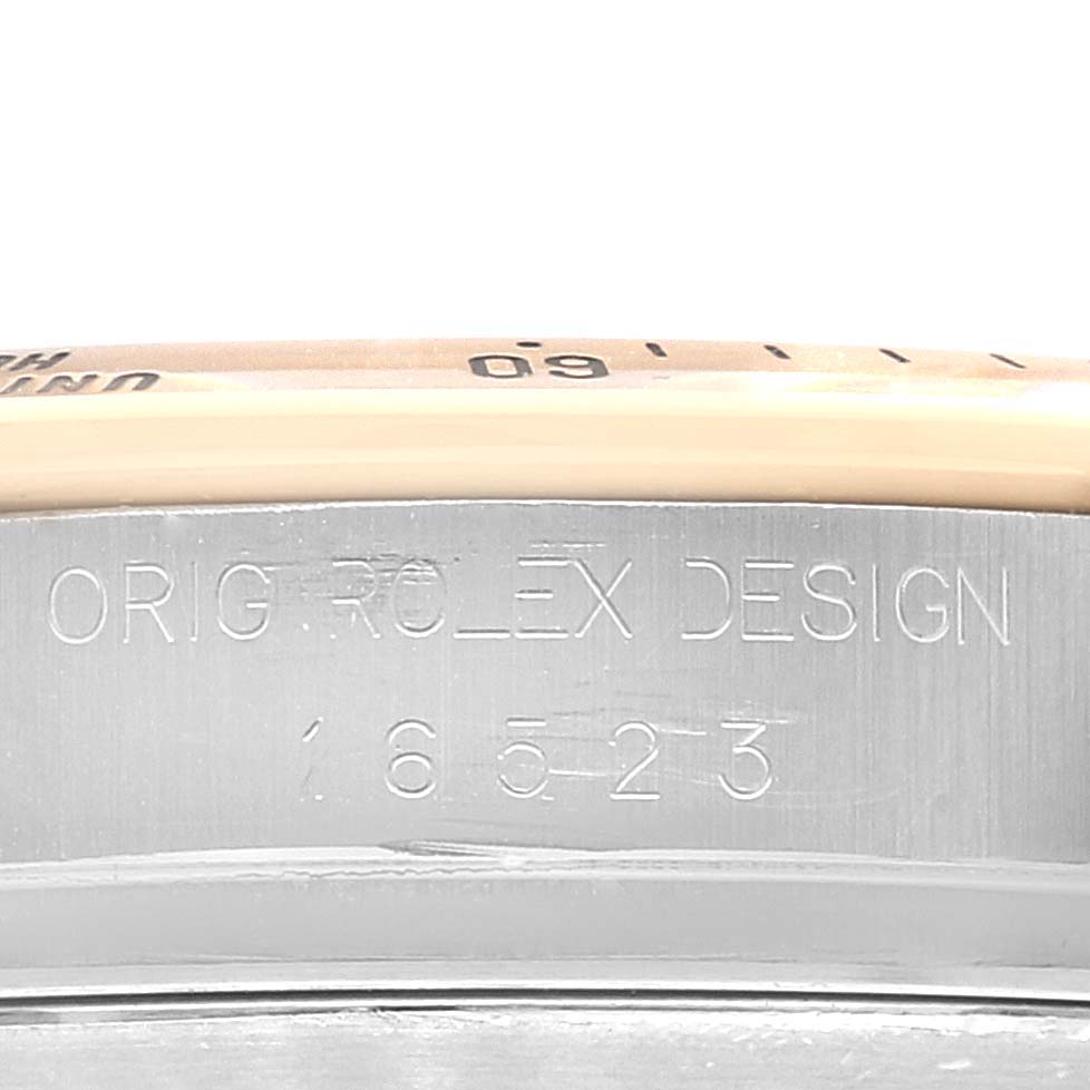 The image shows a close-up of the case side, bezel, and engraved model number of a Rolex Daytona 16523 Men's Steel and Gold (two tone) Black Dial 16523 Men's Steel and Gold (two tone) Black Dial watch.