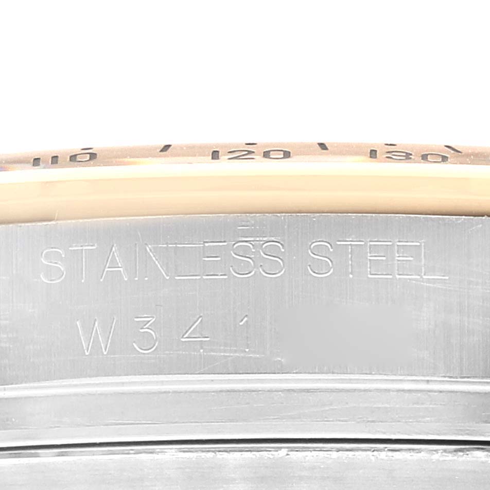 The image shows a close-up of the side of a Rolex Daytona 16523 Men's Steel and Gold (two tone) Black Dial 16523 Men's Steel and Gold (two tone) Black Dial watch case, displaying the "Stainless Steel" inscription and a partial bezel.
