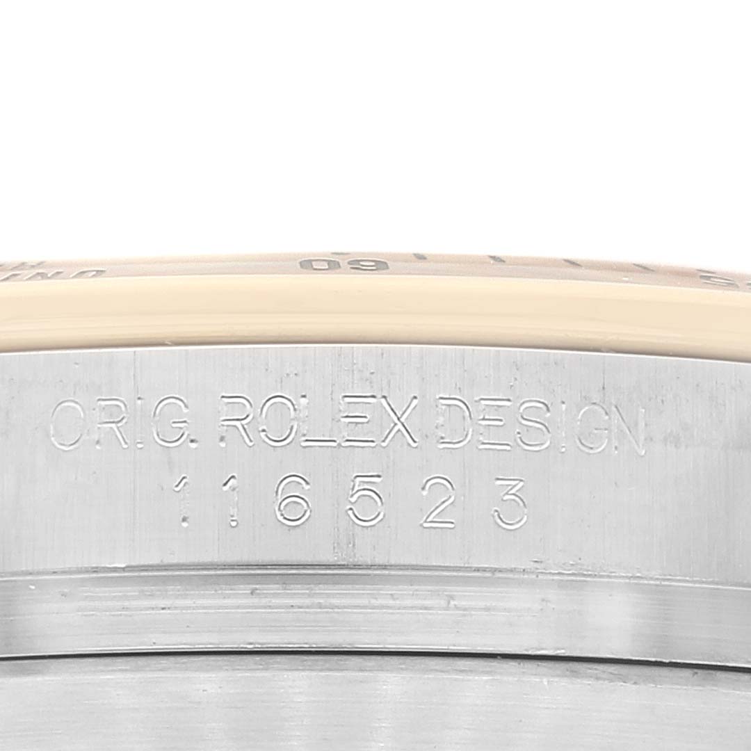 This image shows a close-up of the side of a Rolex Daytona 116523 Men's Steel and Gold (two tone) Mother of Pearl Dial 116523 Men's Steel and Gold (two tone) Mother of Pearl Dial watch, specifically focusing on the model number and engraving.