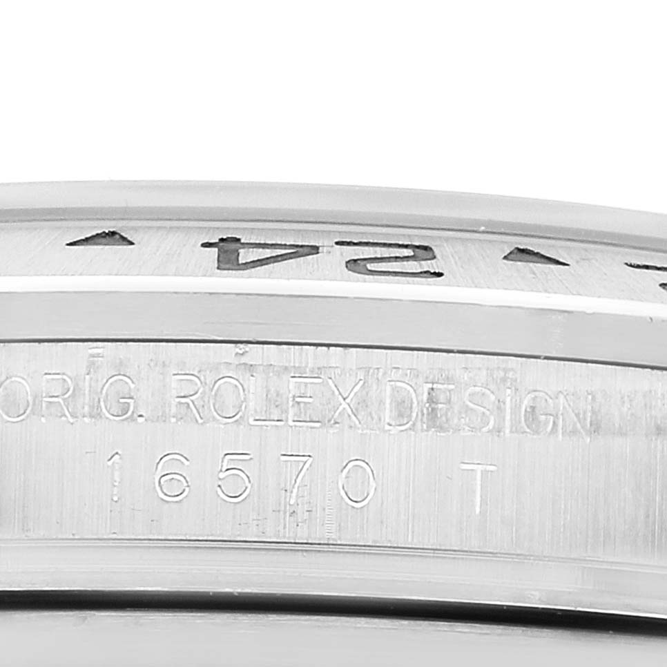 The image shows a close-up of the bezel and case side of a Rolex Explorer 16570 Men's Stainless Steel White Dial 16570 Men's Stainless Steel White Dial watch model 16570 T with engraved markings.
