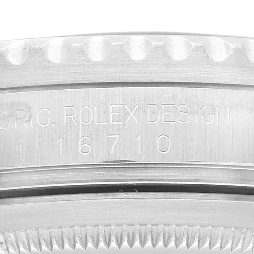 The image shows a close-up view of the side of a Rolex GMT-Master 16710 Men
s Stainless Steel Black Dial 16710 Men
s Stainless Steel Black Dial bezel, including the model number "16710" and "ORIG. ROLEX DESIGN" engraving.