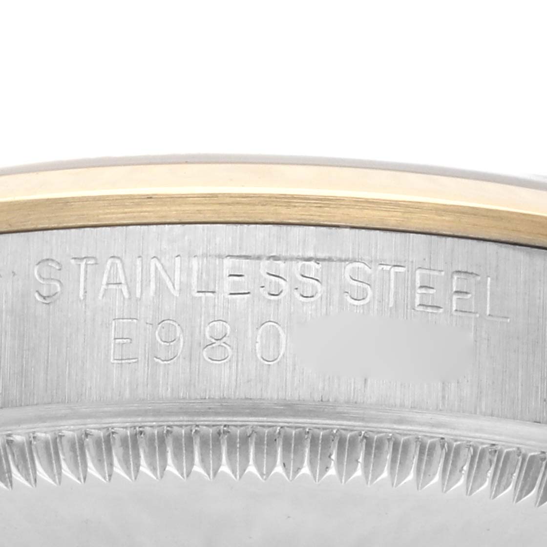 The image shows the side view of a Rolex Mid-Size 67483 Women's Steel and Gold (two tone) White Dial 67483 Women's Steel and Gold (two tone) White Dial model, highlighting the engraved "Stainless Steel" on the case edge.