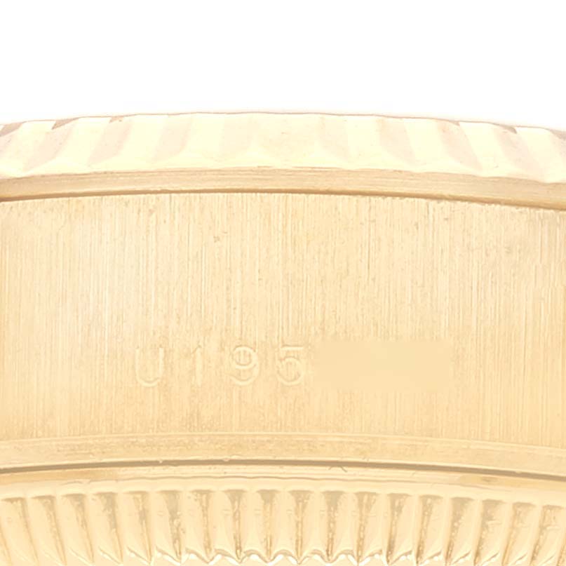 The image shows a close-up of the side of a Rolex President 79178 Women
s Yellow Gold Champagne Dial 79178 Women
s Yellow Gold Champagne Dial model watch, highlighting its fluted bezel and partially visible serial number.