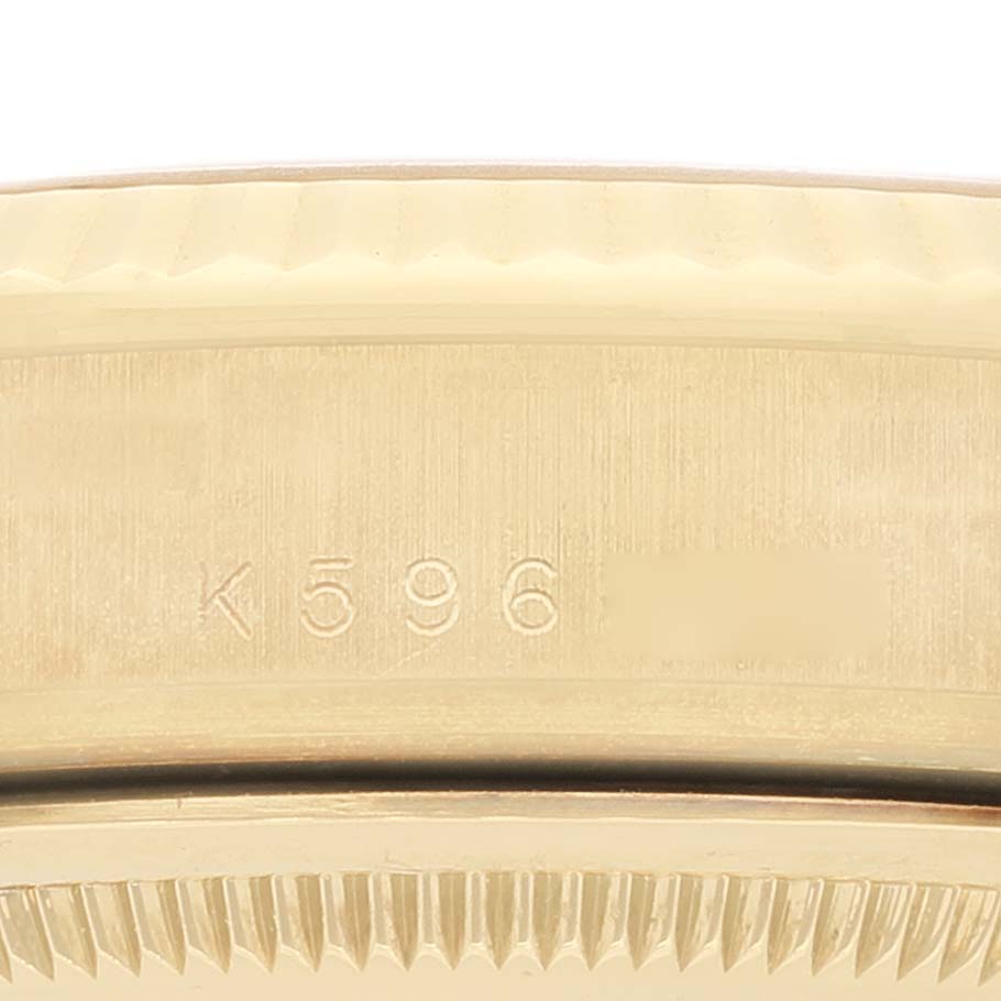 Close-up of a Rolex President 118338 Men
s Yellow Gold  118338 Men
s Yellow Gold  model showing the side of the case with engraved serial numbers and part of the bezel.