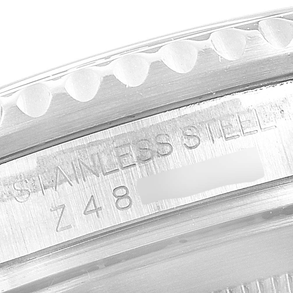This close-up image shows the engraved serial number and "STAINLESS STEEL" text on the bezel edge of a Rolex Submariner 16610 Men's Stainless Steel Black Dial 16610 Men's Stainless Steel Black Dial watch.