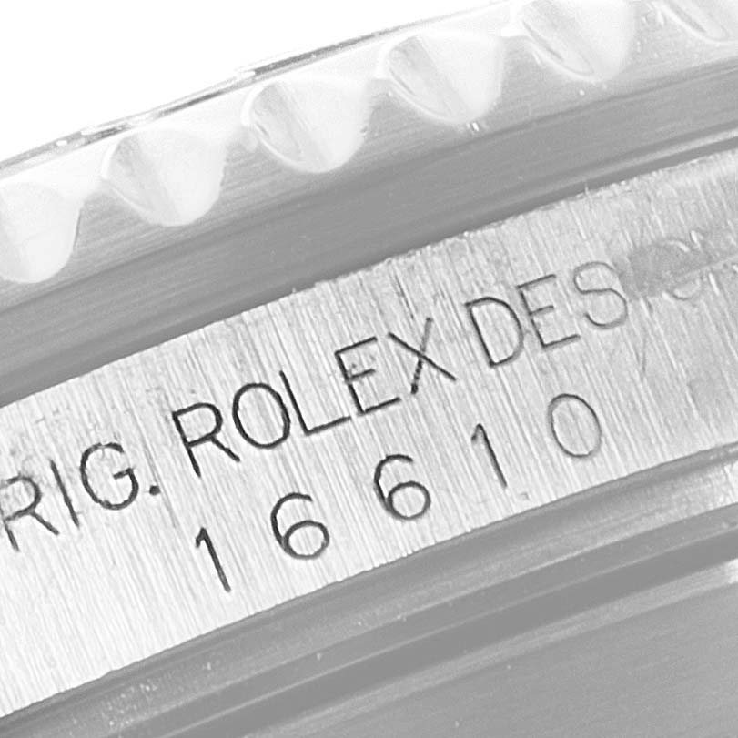 The image shows a close-up of the case side of a Rolex Submariner 16610 Men
s Stainless Steel Black Dial 16610 Men
s Stainless Steel Black Dial, highlighting the engraved model number.