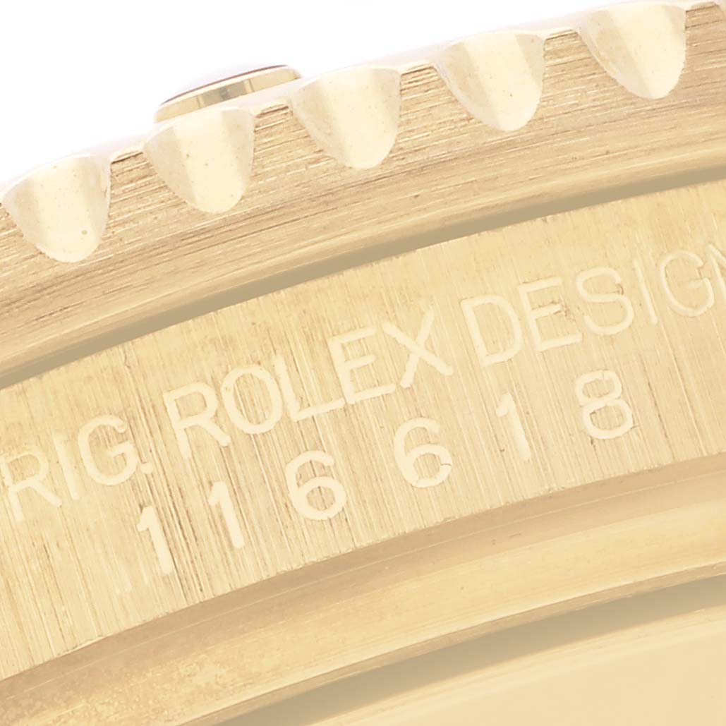 The image shows a close-up of the gold bezel edge and engraved side of a Rolex Submariner 116618 Men's Yellow Gold Black Dial 116618 Men's Yellow Gold Black Dial.