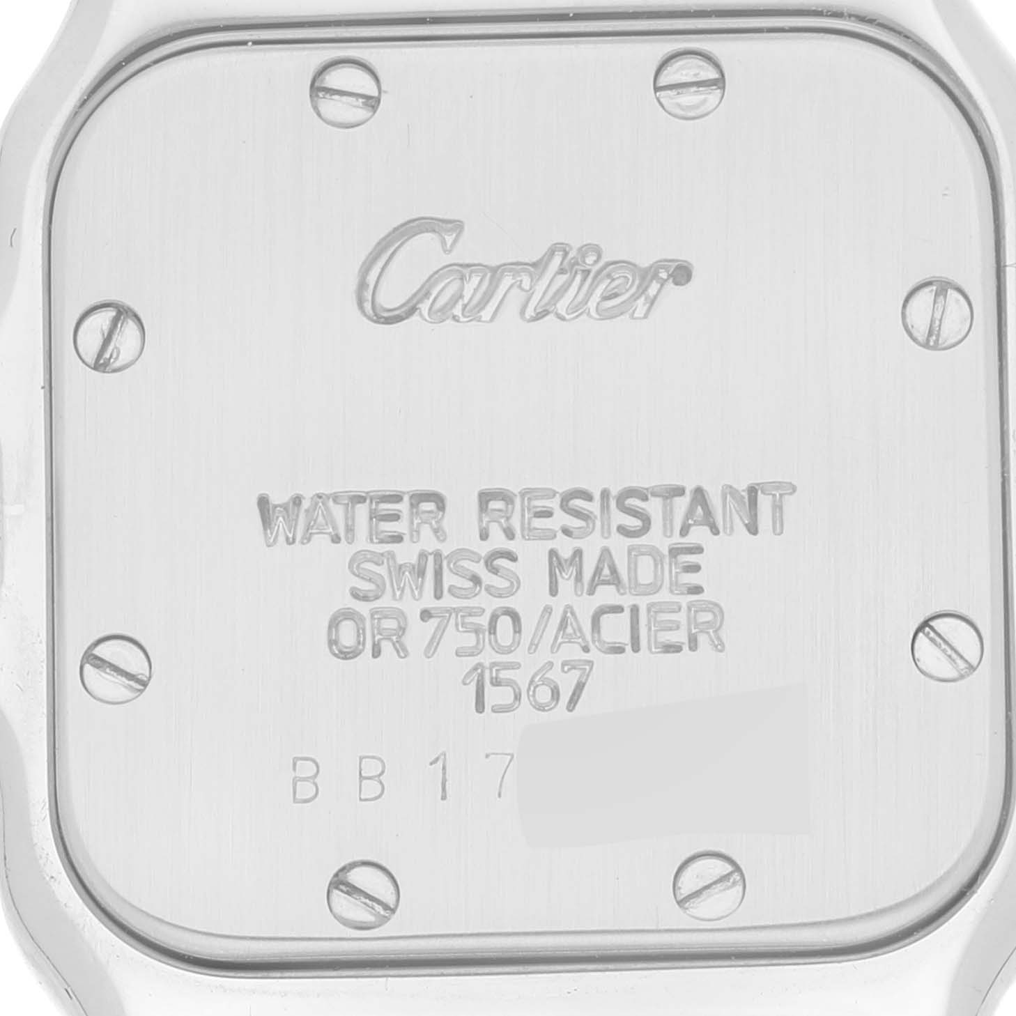 This image shows the back case of a Santos model watch by Cartier, featuring engraved details and screws.