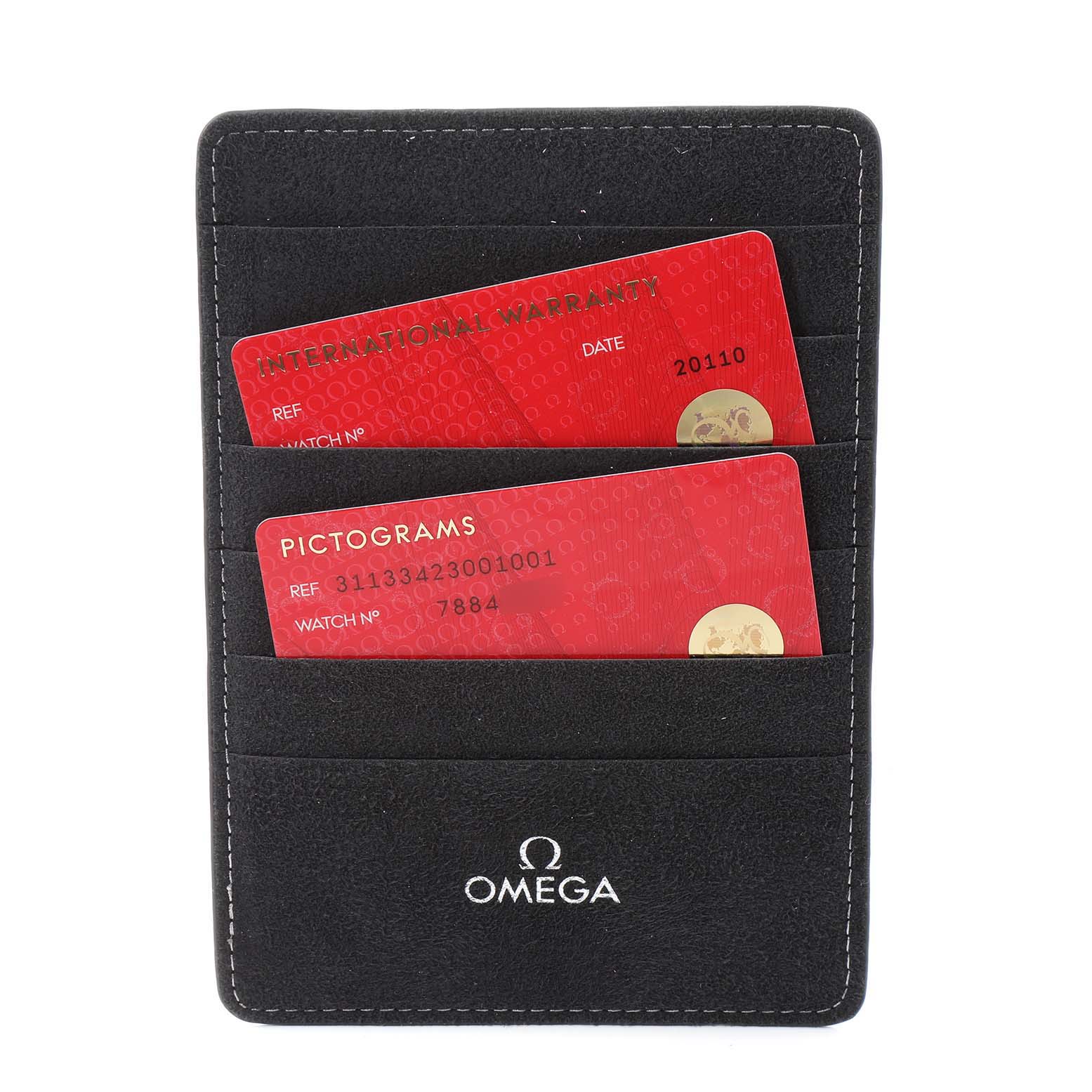 The image shows a black Omega cardholder containing an International Warranty card and a Pictograms card for the Speedmaster model by Omega.
