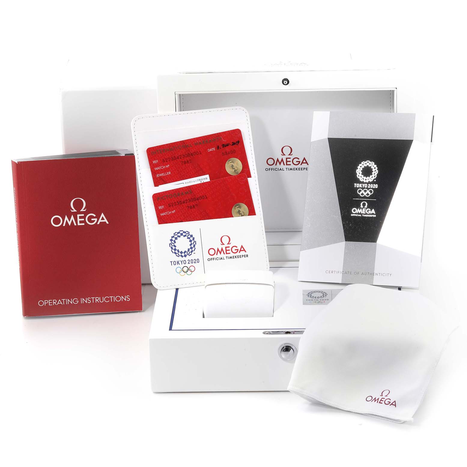 The image displays the accessories for an Omega Speedmaster 522.30.42.30.04.001 Men's Stainless Steel White Dial 522.30.42.30.04.001 Men's Stainless Steel White Dial, including a box, manuals, warranty cards, and a cleaning cloth.