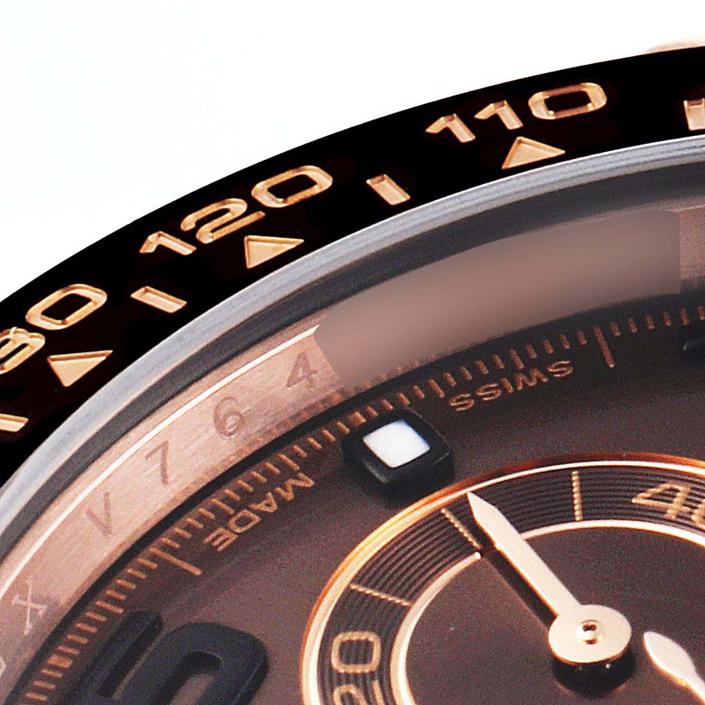 The close-up angle of this Rolex Daytona 116515 Men's Rose Gold Brown Dial 116515 Men's Rose Gold Brown Dial watch shows part of the bezel, dial, and a minute-hand marker.