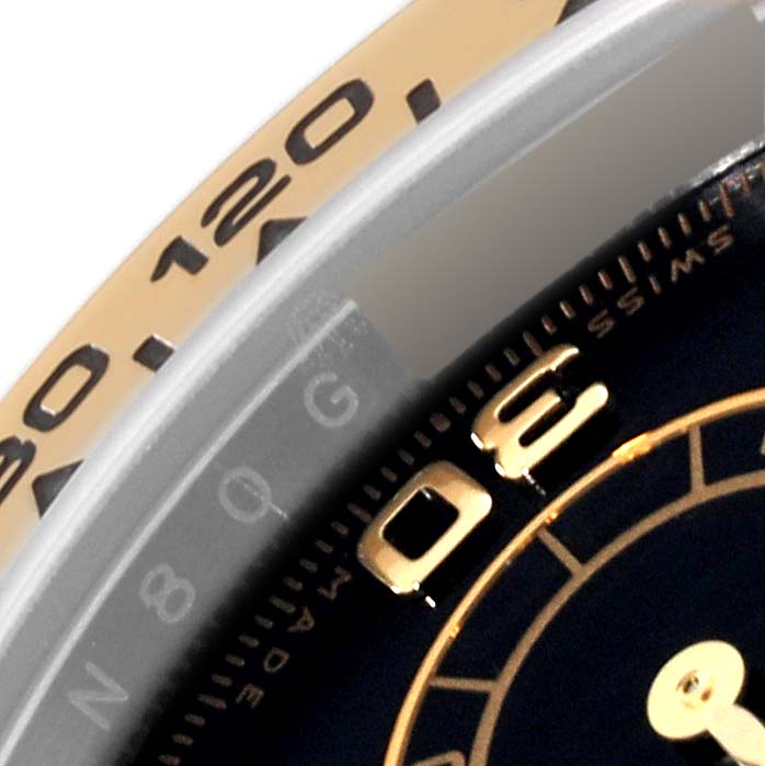 The image shows a close-up of the bezel and dial of a Rolex Daytona 116503 Men
s Steel and Gold (two tone) Black Dial 116503 Men
s Steel and Gold (two tone) Black Dial watch.