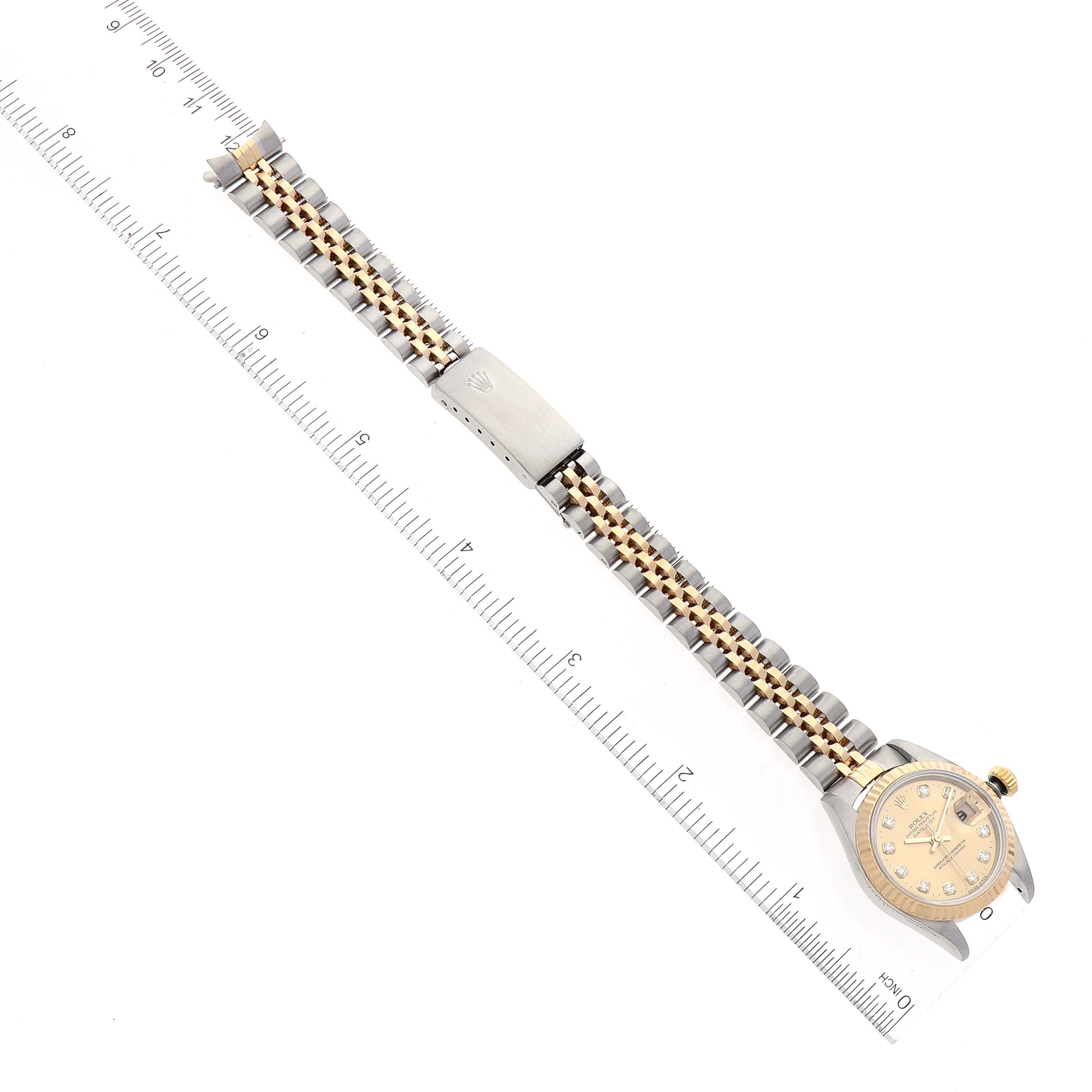 The image shows an overhead view of a Rolex Datejust 69173 Women's Steel and Gold (two tone) Champagne Dial 69173 Women's Steel and Gold (two tone) Champagne Dial watch, displaying its face, bezel, bracelet, and clasp, alongside a ruler.