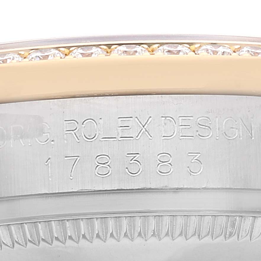 This close-up image shows the side of a Rolex Mid-Size 178383 Women
s Steel and Gold (two tone) Champagne Dial 178383 Women
s Steel and Gold (two tone) Champagne Dial watch case, highlighting the "ROLEX DESIGN" engraving and model number 178383.