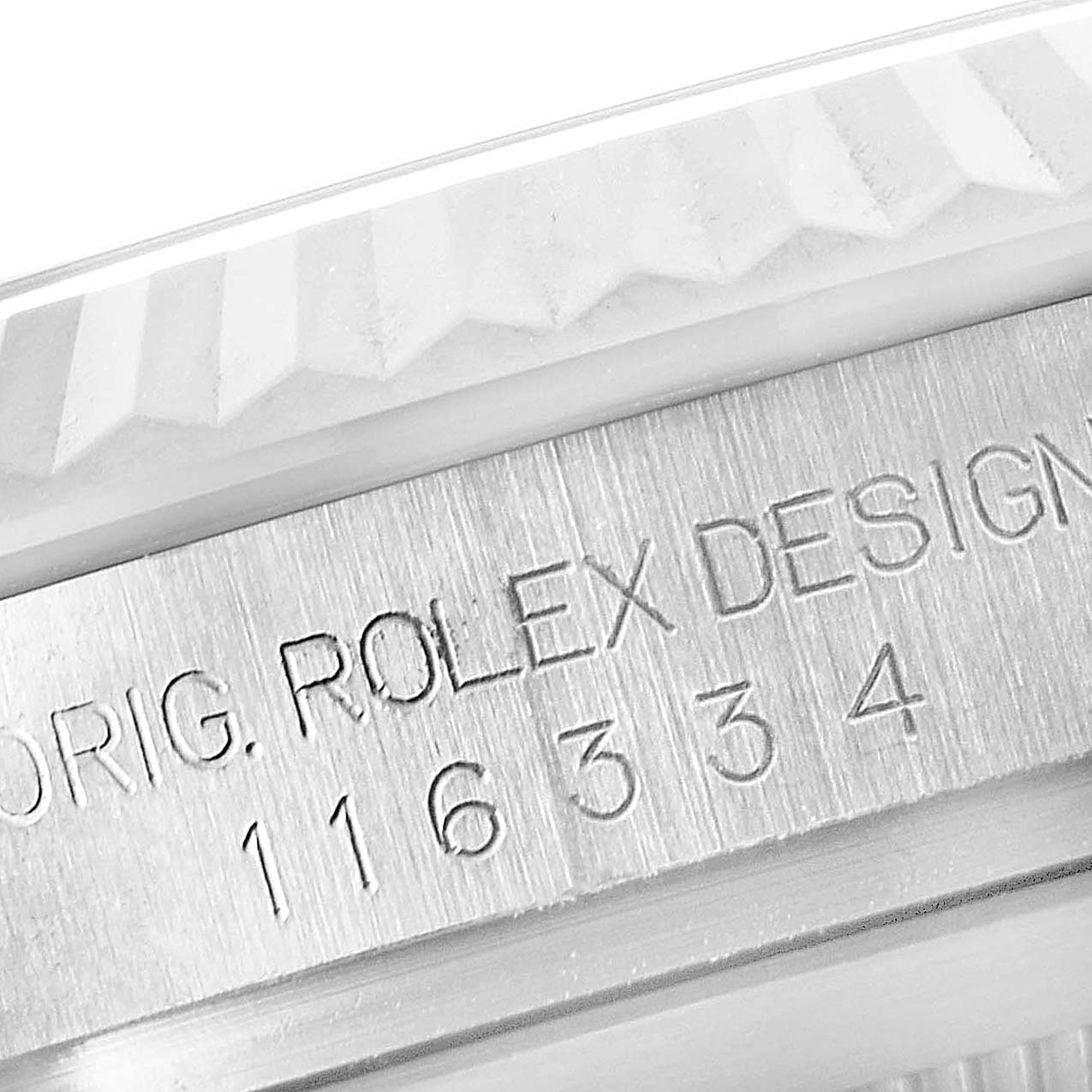 The image shows a close-up of the side of a Rolex Datejust 41 116334 Men
s Stainless Steel Black Dial 116334 Men
s Stainless Steel Black Dial watch, focusing on the engraved serial number and "Rolex Design."