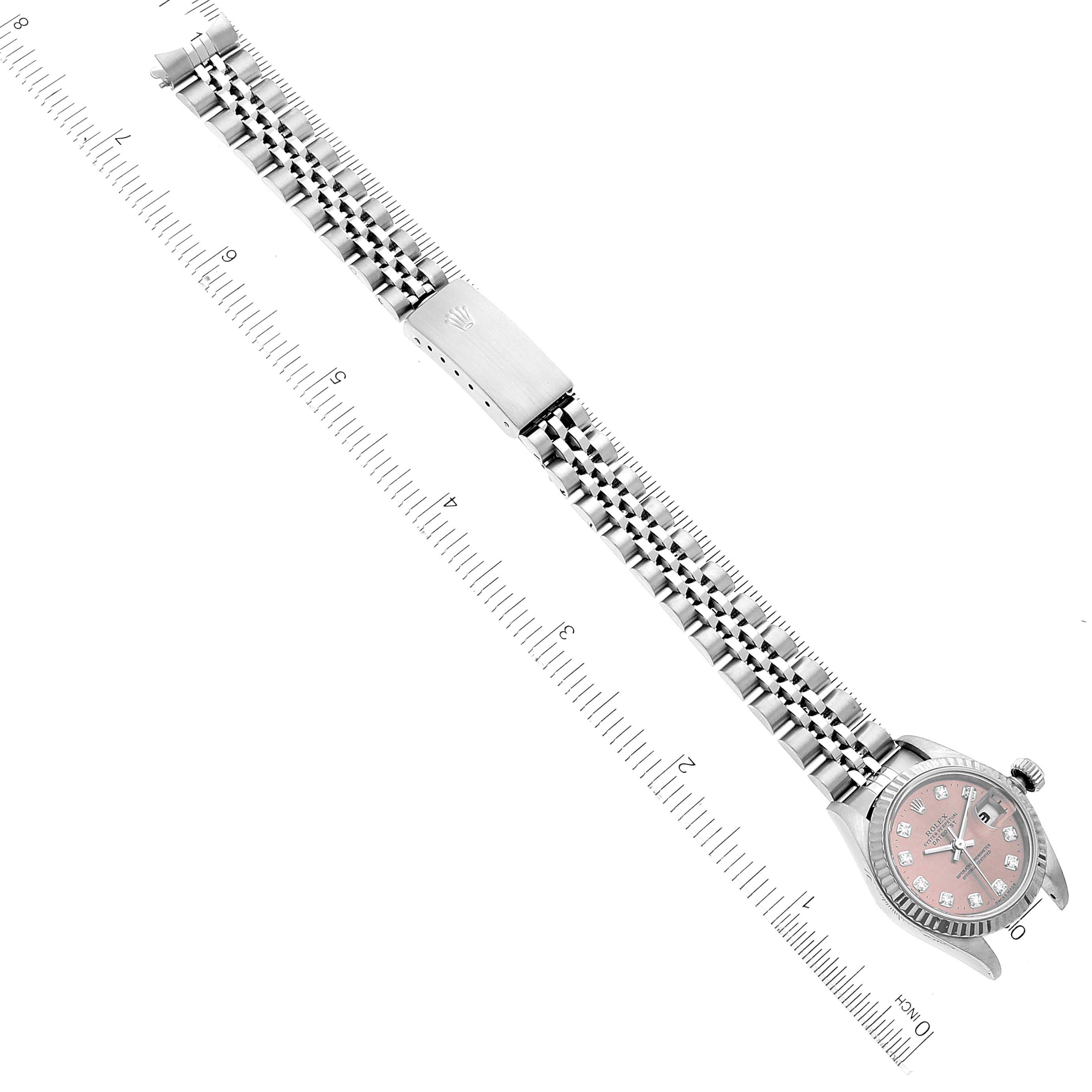 The image shows a Rolex Datejust 69174 Women's Stainless Steel Pink Dial 69174 Women's Stainless Steel Pink Dial watch laid flat with its jubilee bracelet extended, next to a ruler for size reference.