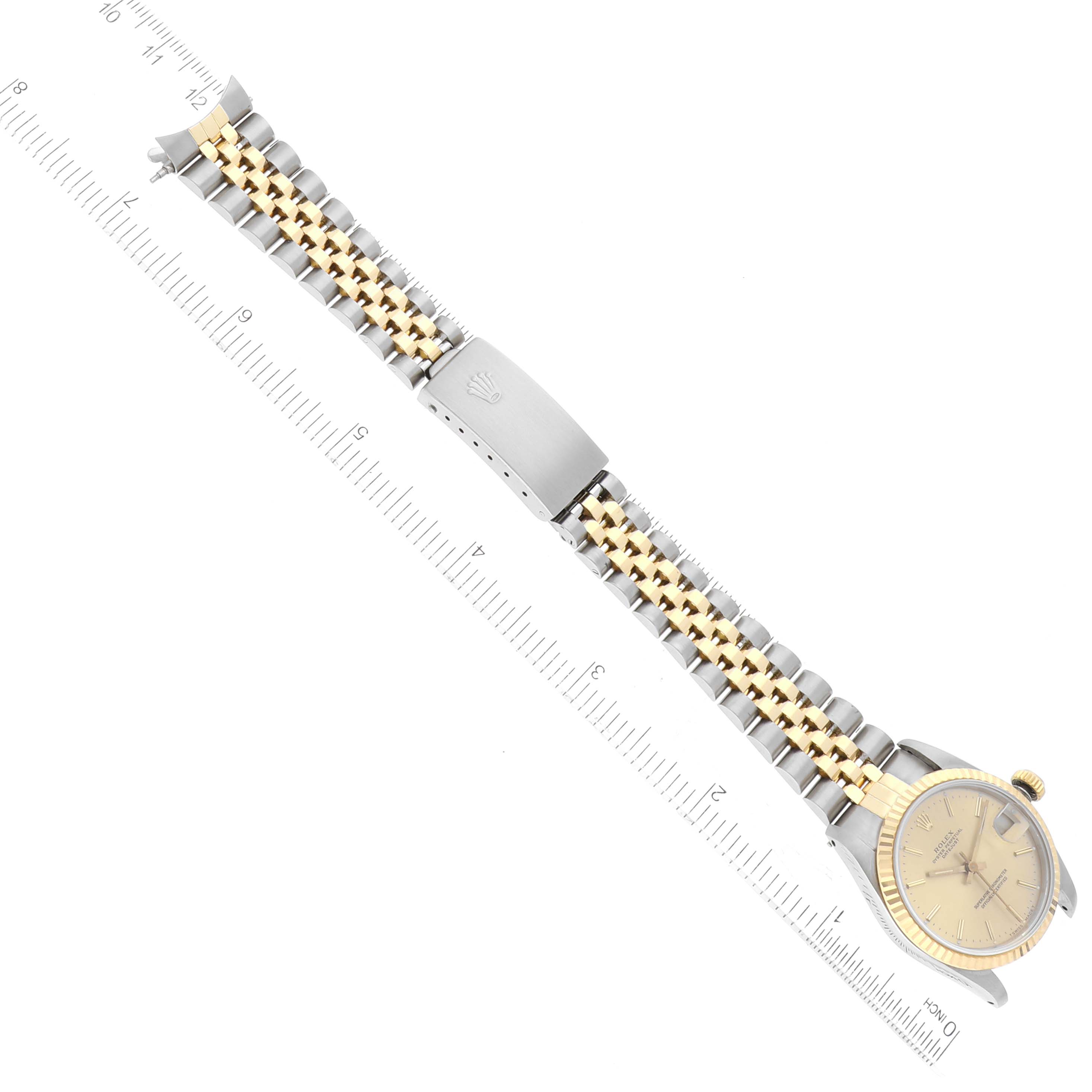 The image shows an overhead view of a Rolex Mid-Size 68273 Women's Steel and Gold (two tone) Champagne Dial 68273 Women's Steel and Gold (two tone) Champagne Dial watch displaying the dial, case, and band with a ruler for scale.