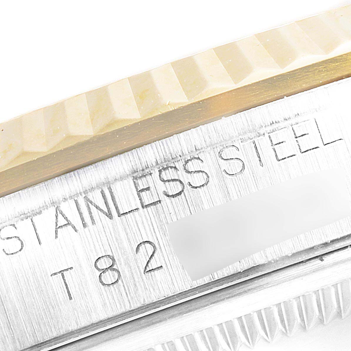 The image shows a close-up angle of the Rolex Datejust 16233 Men's Steel and Gold (two tone) Champagne Dial 16233 Men's Steel and Gold (two tone) Champagne Dial's bezel and case with "STAINLESS STEEL" engraved.