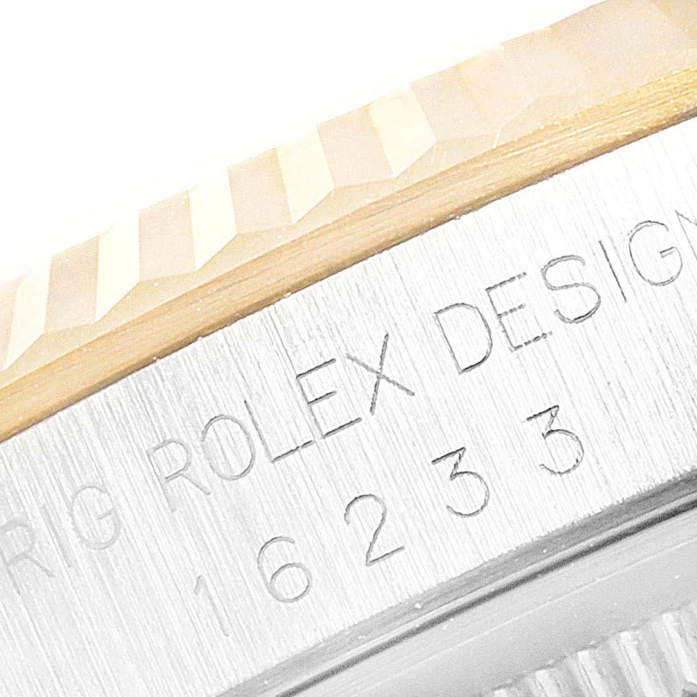 The image shows a close-up of the bezel and the engraved side of the case of a Rolex Datejust 16233 Men's Steel and Gold (two tone) Champagne Dial 16233 Men's Steel and Gold (two tone) Champagne Dial watch.