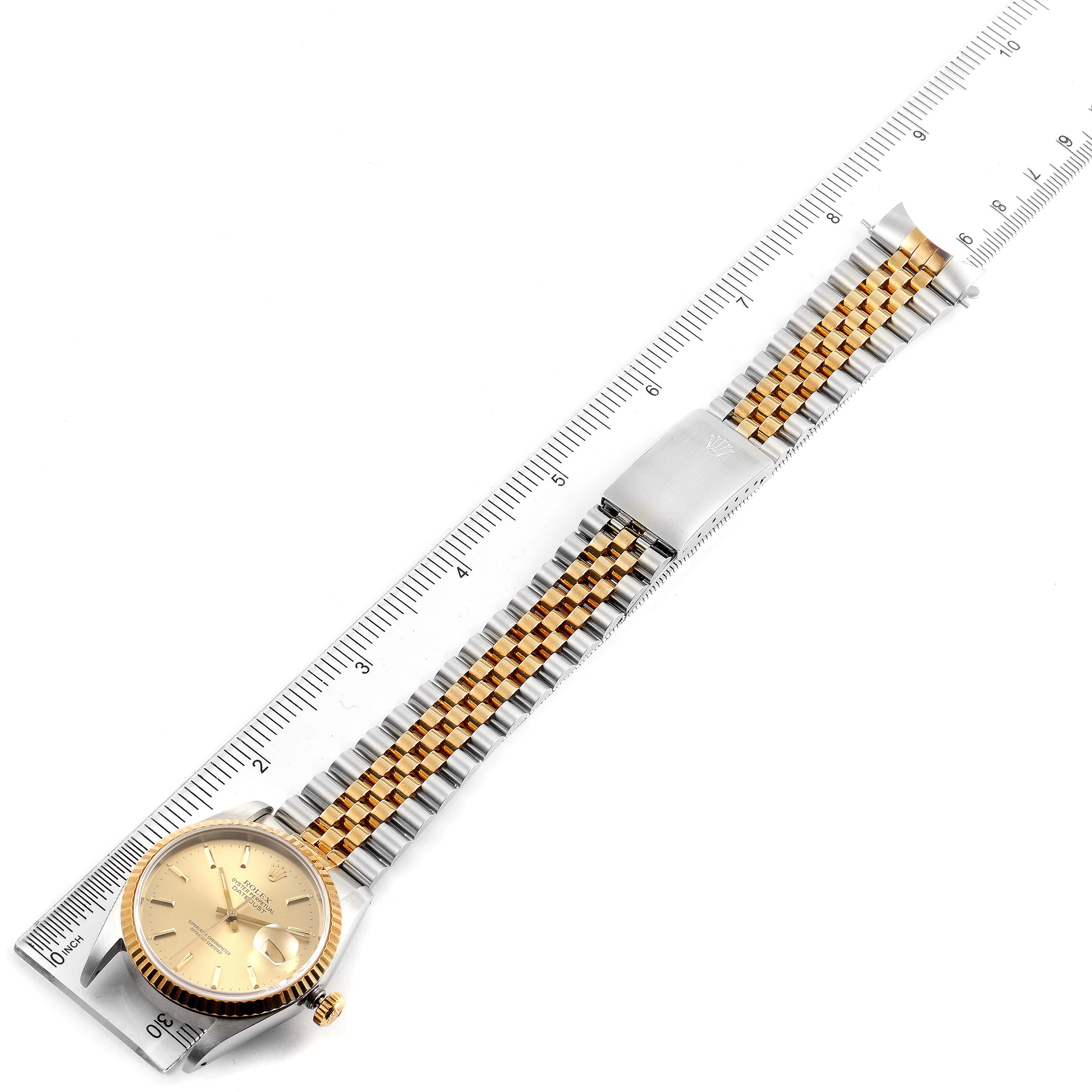 The image shows a Rolex Datejust 16233 Men's Steel and Gold (two tone) Champagne Dial 16233 Men's Steel and Gold (two tone) Champagne Dial watch laid flat, displaying the full watch band and dial from an overhead angle next to a ruler.