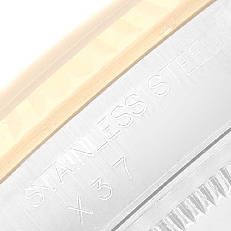 The image shows a close-up of the Rolex Datejust 16233 Men's Steel and Gold (two tone) Black Dial 16233 Men's Steel and Gold (two tone) Black Dial model's case with engravings reading "Stainless Steel" and part of the bezel.