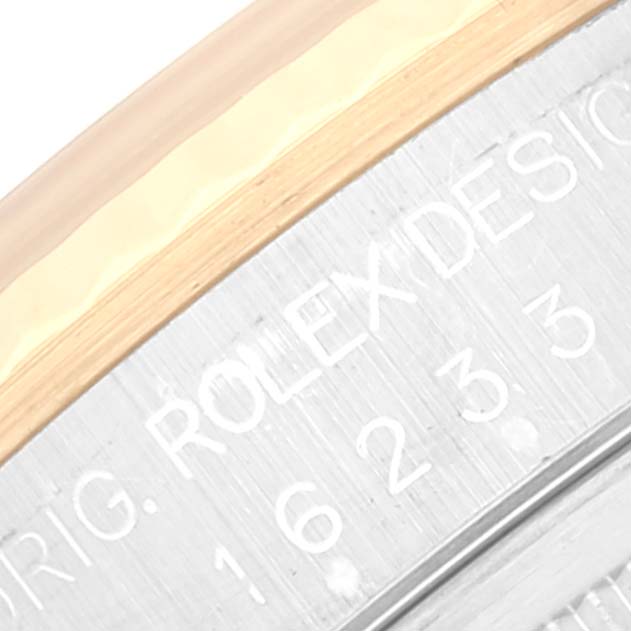 The image shows a close-up of the Rolex Datejust 16233 Men's Steel and Gold (two tone) Champagne Dial 16233 Men's Steel and Gold (two tone) Champagne Dial's bezel and the engraved side of the case.